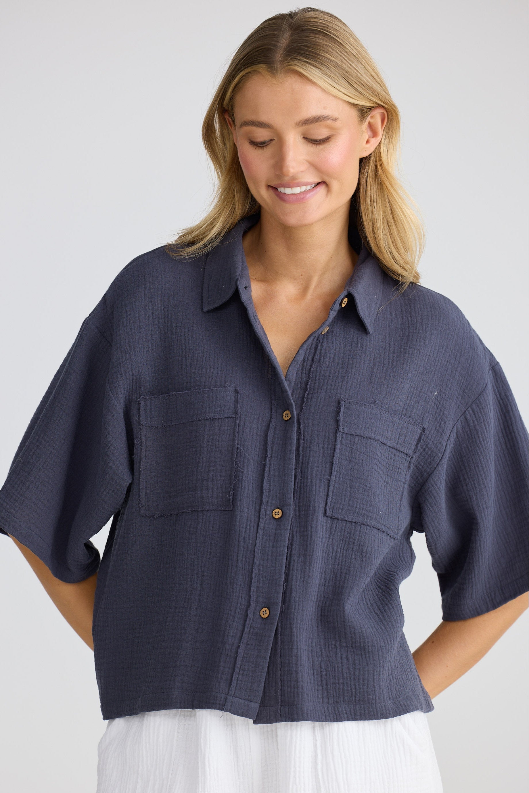 Woman wearing a navy blue shirt with short sleeves on a white background