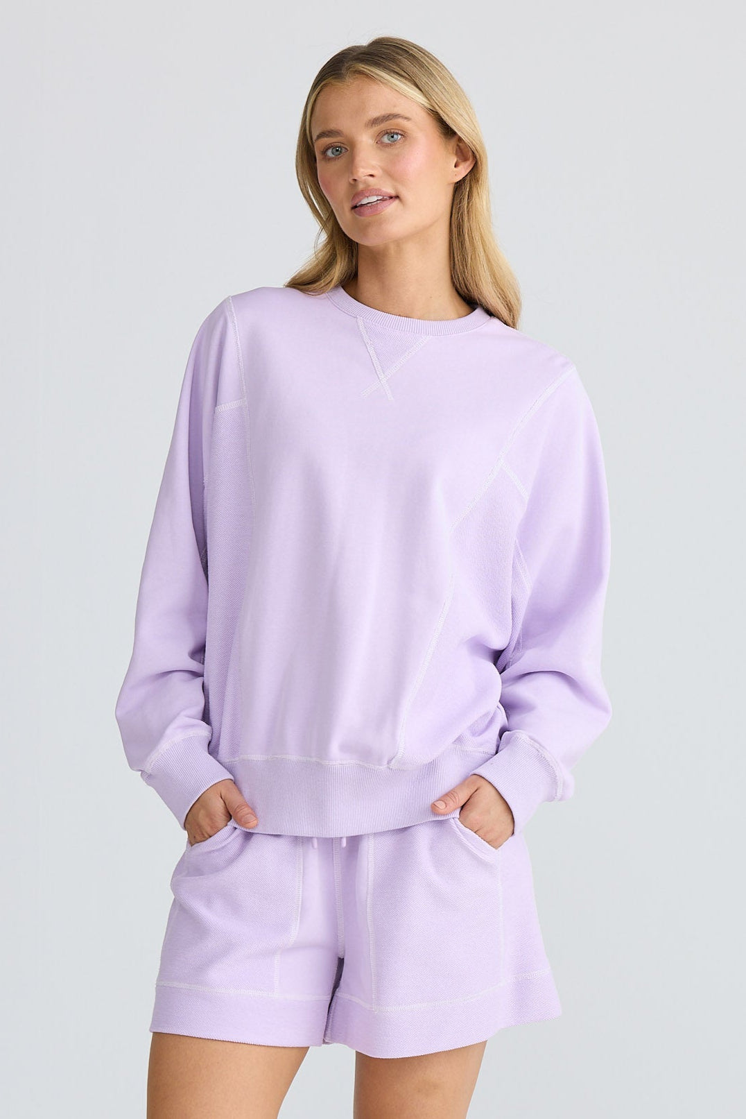 Person wearing a lavender outfit on a white background
