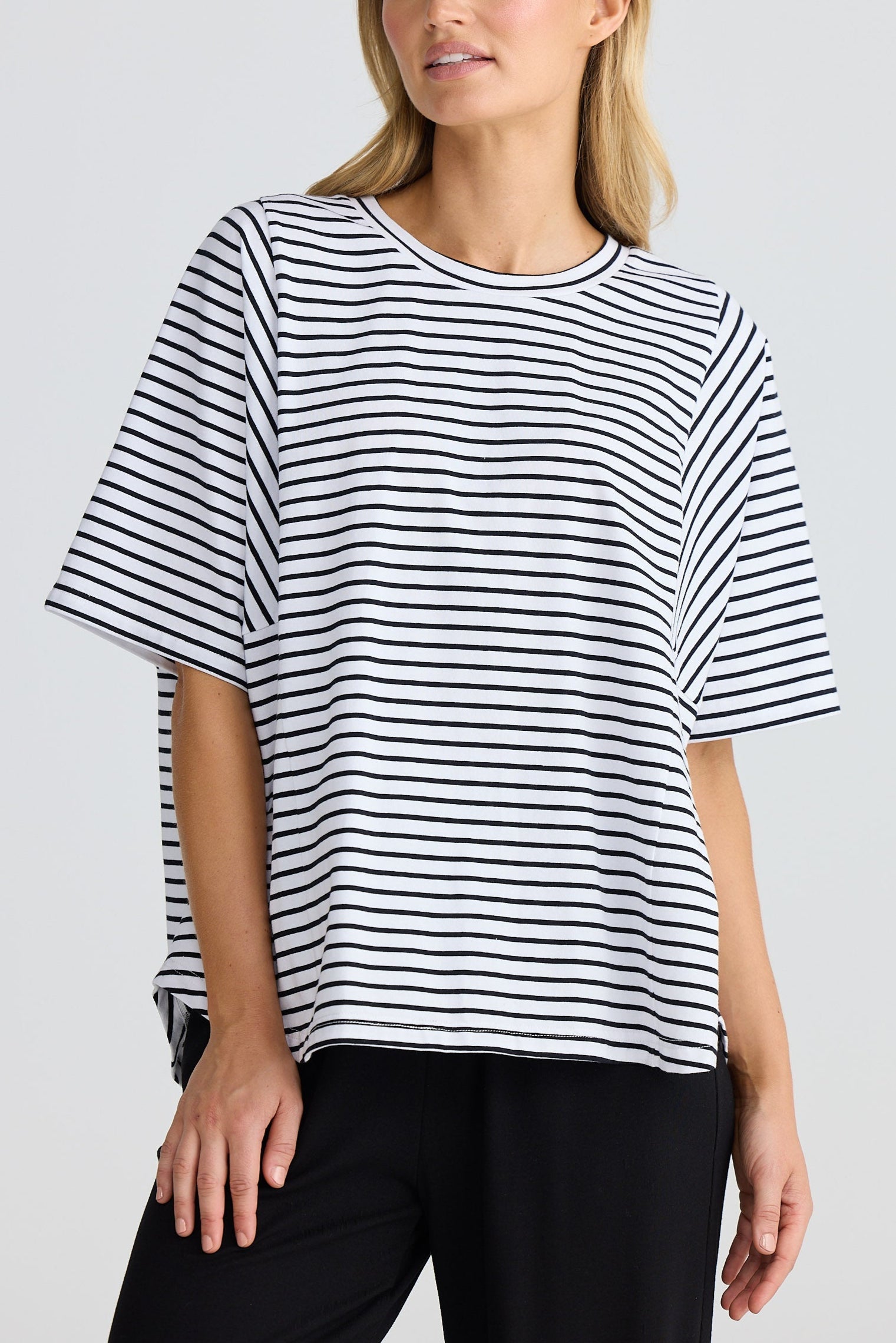 Woman wearing a black and white striped t-shirt against a plain background