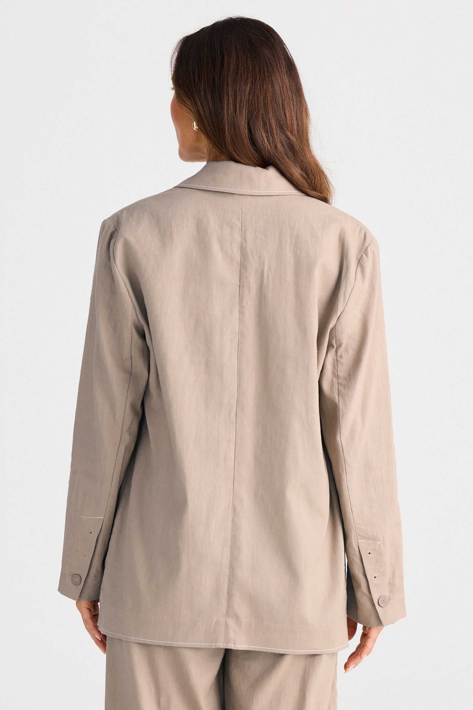Woman wearing a beige suit on a white background