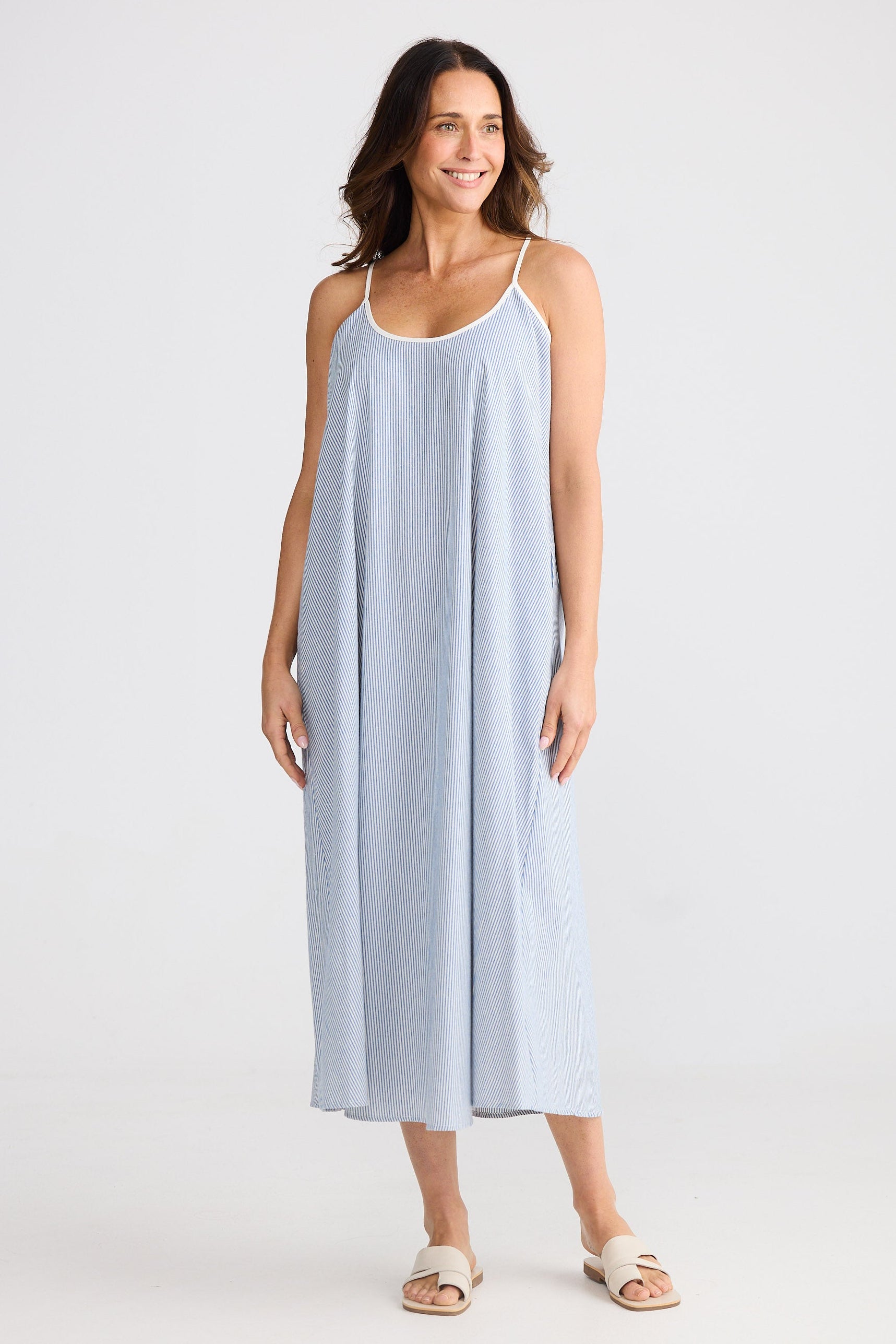 Woman wearing a light blue slip dress on a white background