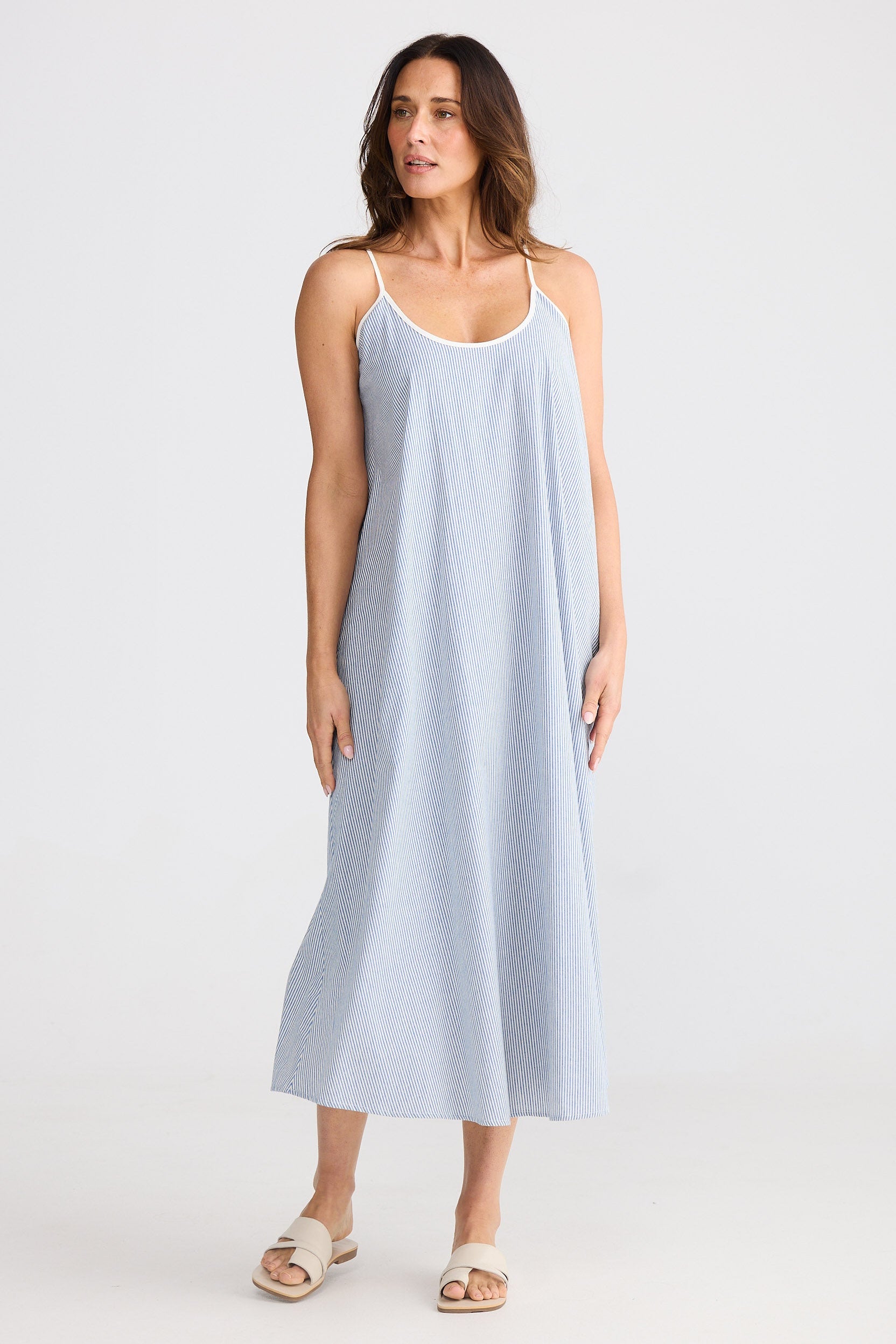 Woman wearing a light blue striped dress on a white background