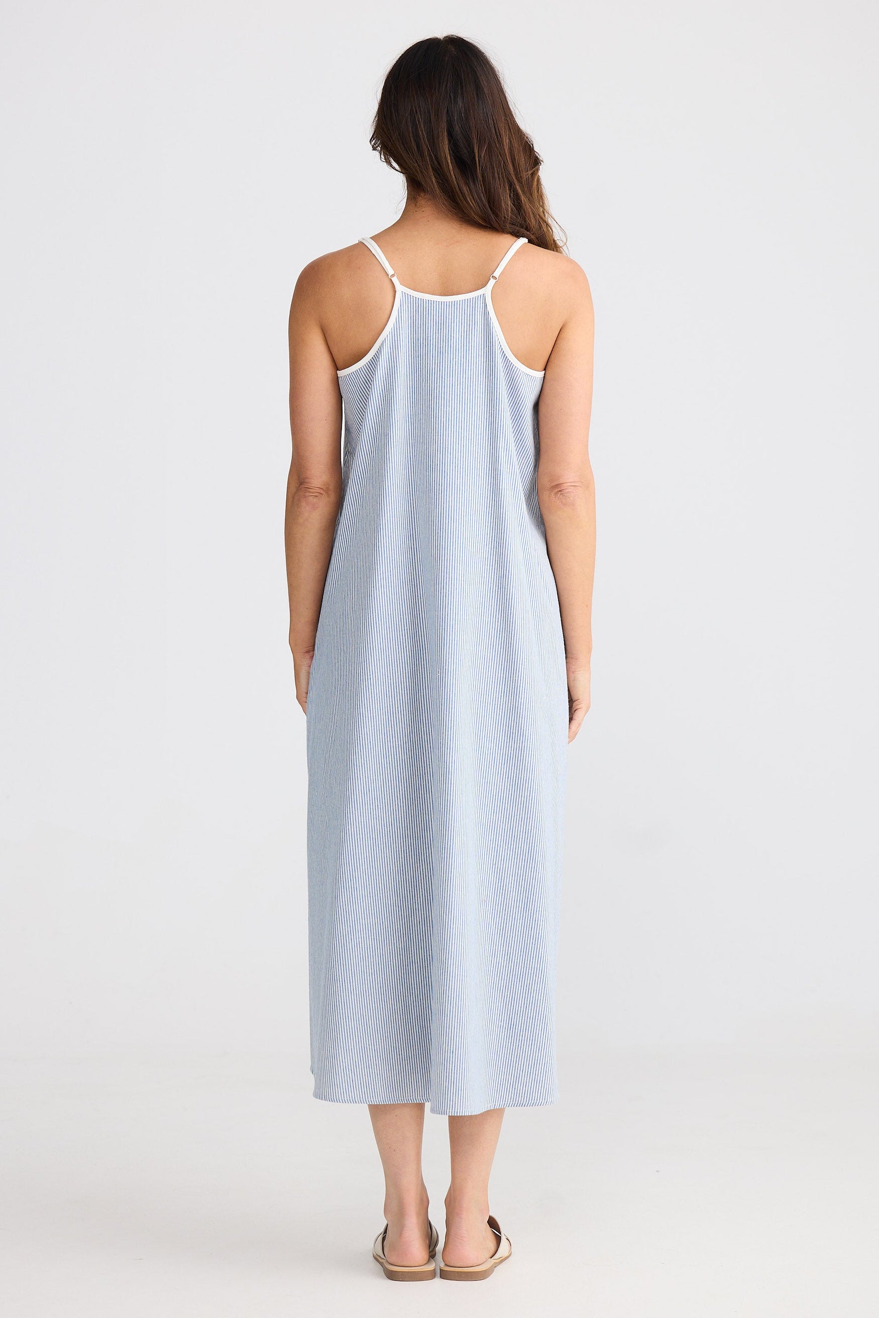 Woman wearing a light blue striped dress on a white background