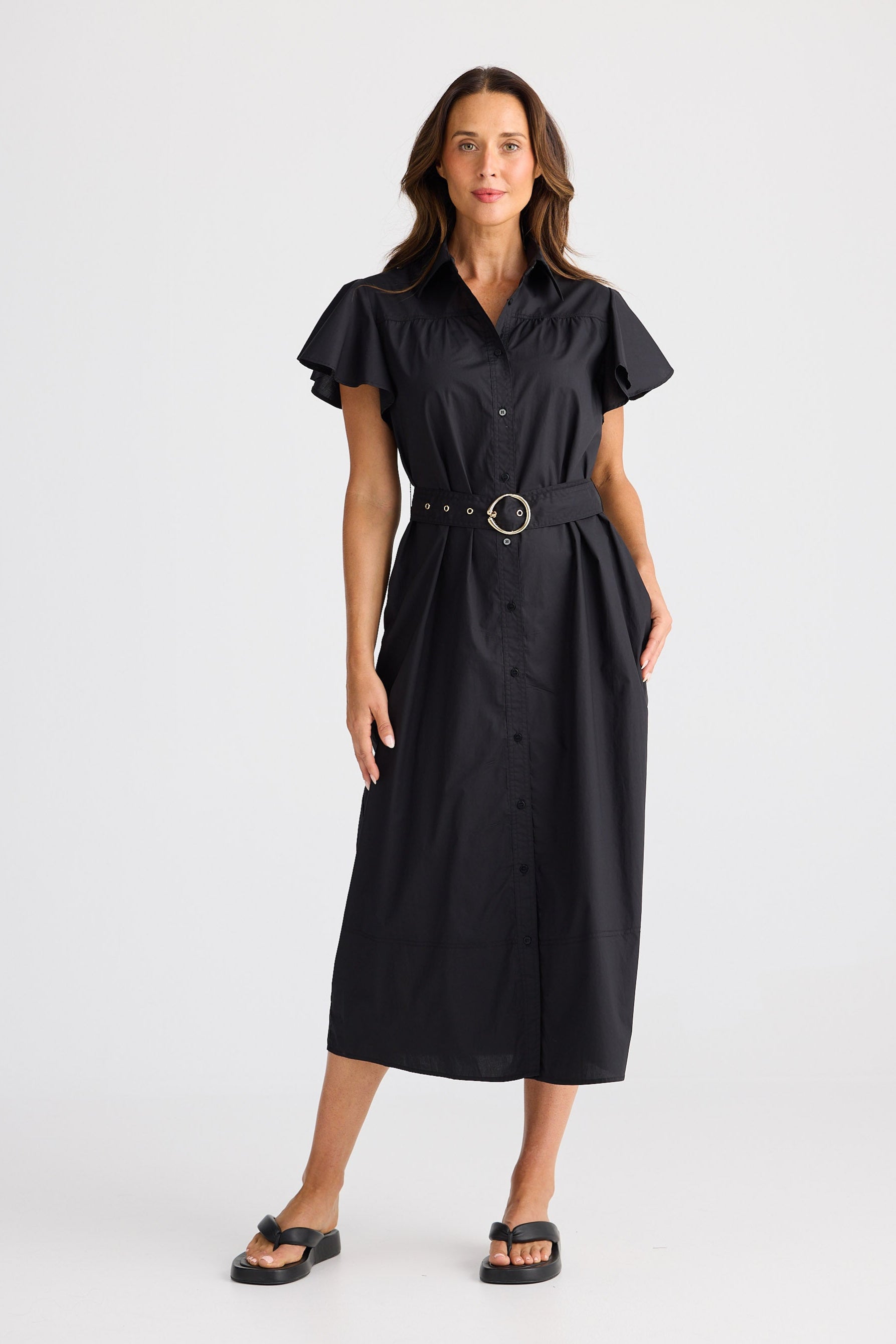Woman wearing a black dress with a belt on a white background
