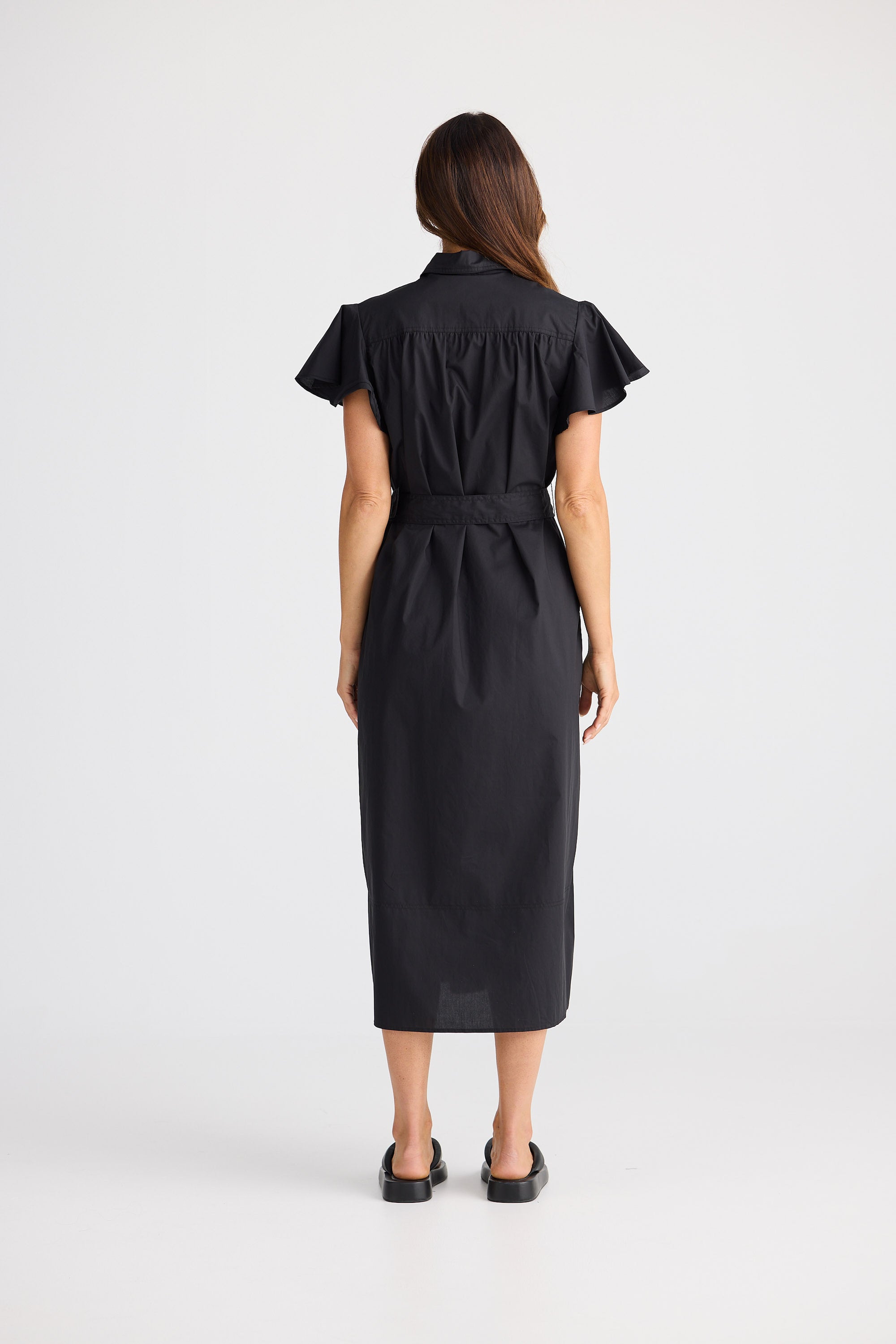 Woman wearing a black dress with a belt on a white background