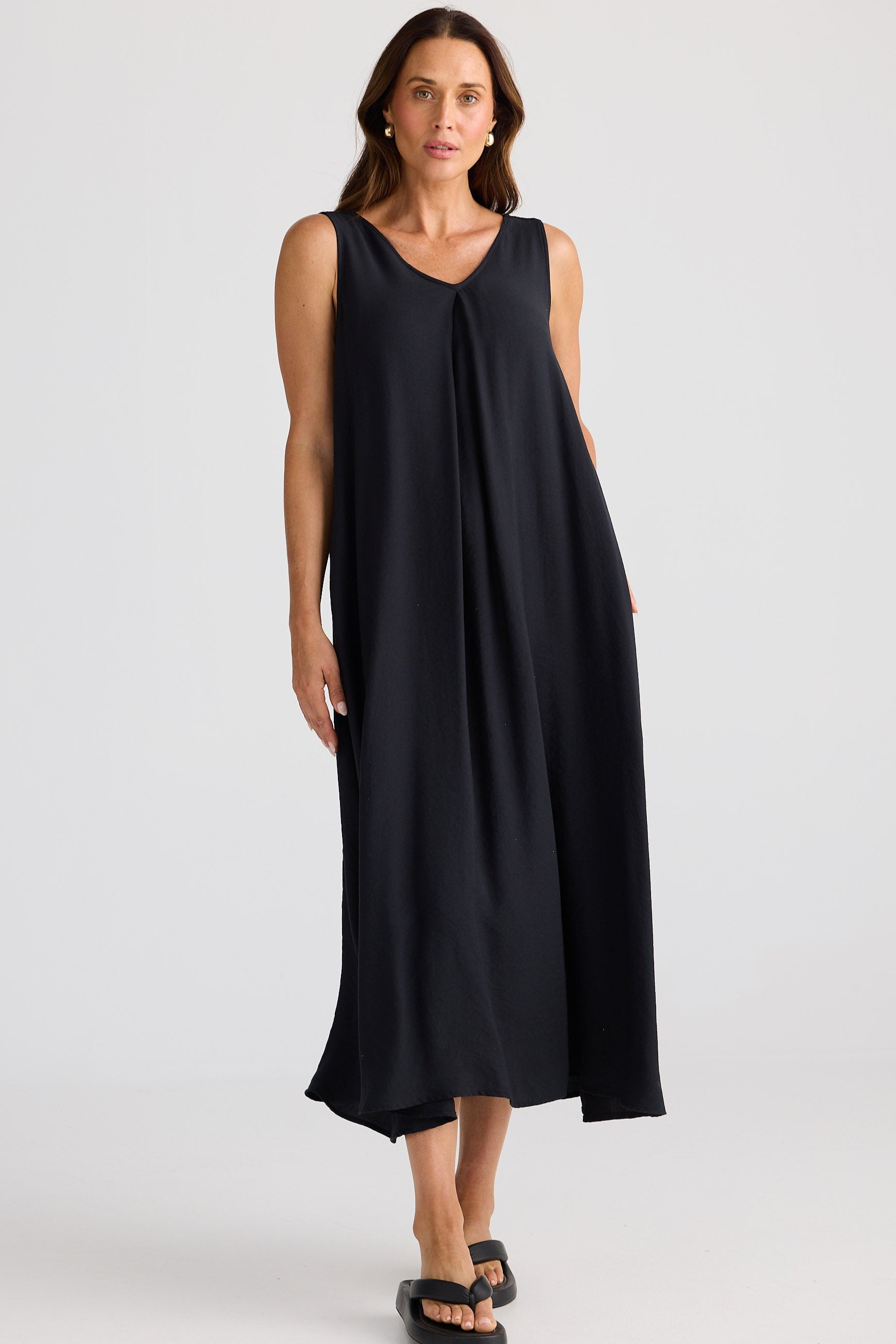 Woman wearing a black sleeveless dress on a white background