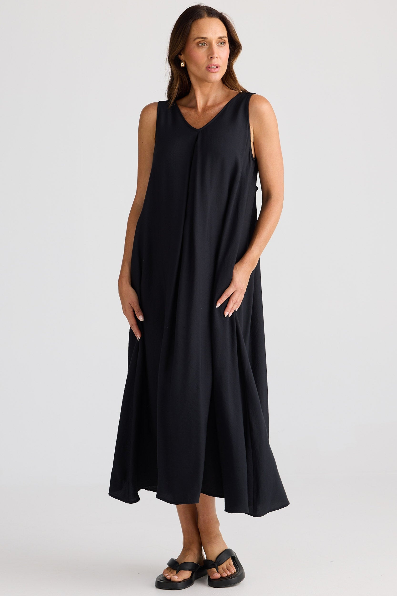Woman wearing a black sleeveless dress on a white background