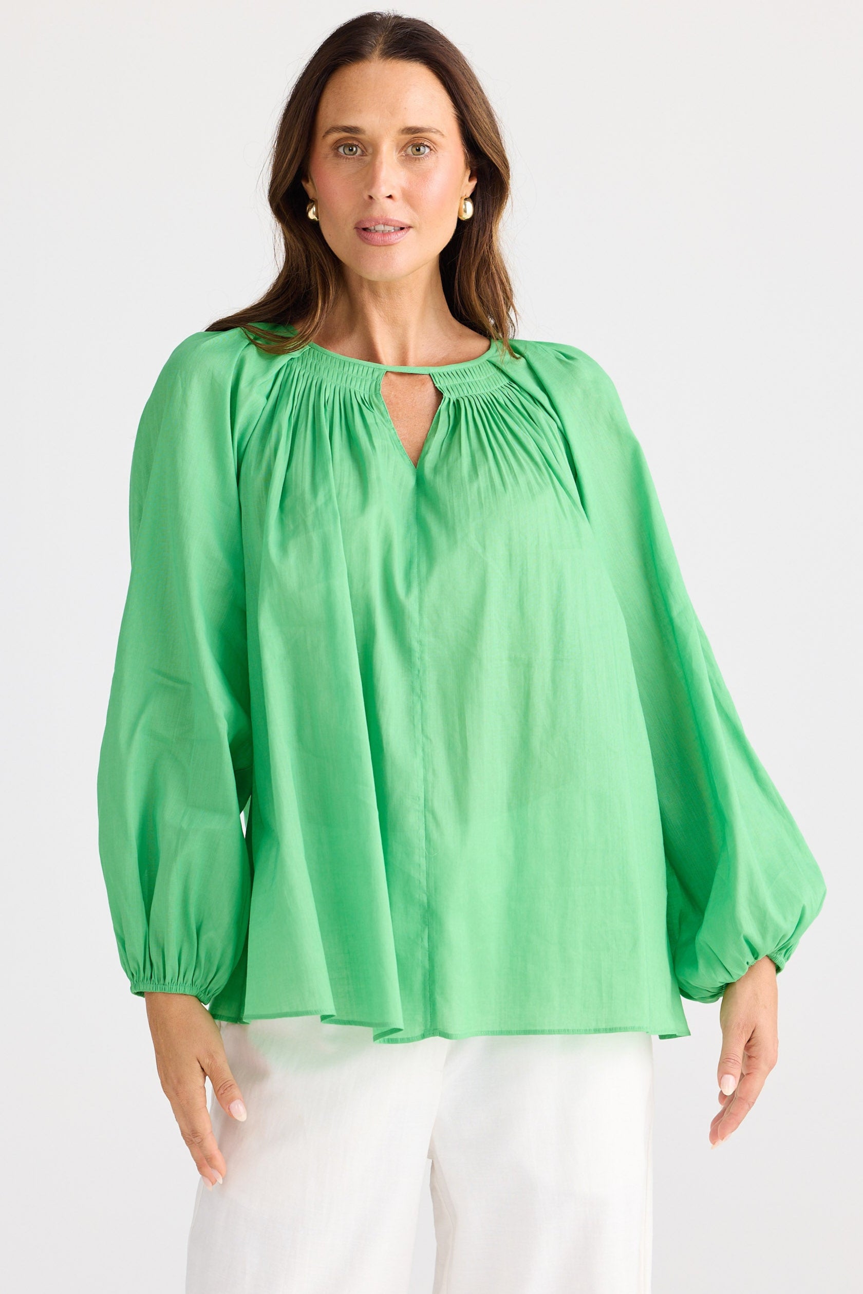 Woman wearing a green blouse with a plain background