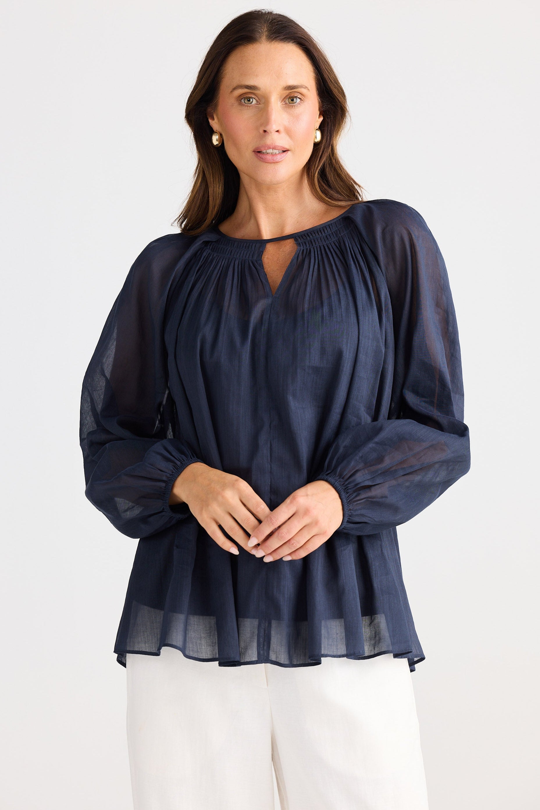 Woman wearing a navy blue blouse with a white background