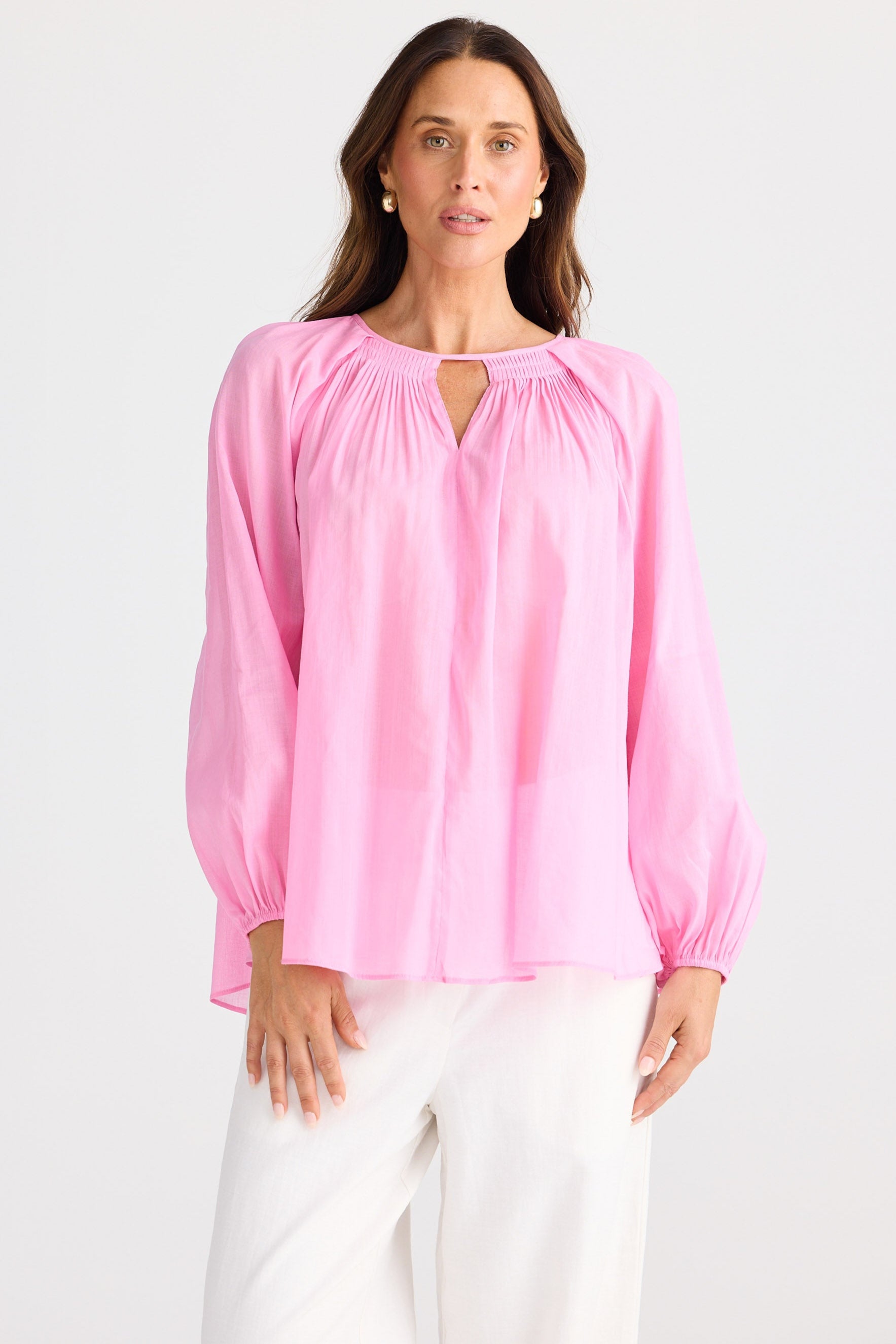 Woman wearing a pink blouse with a white background