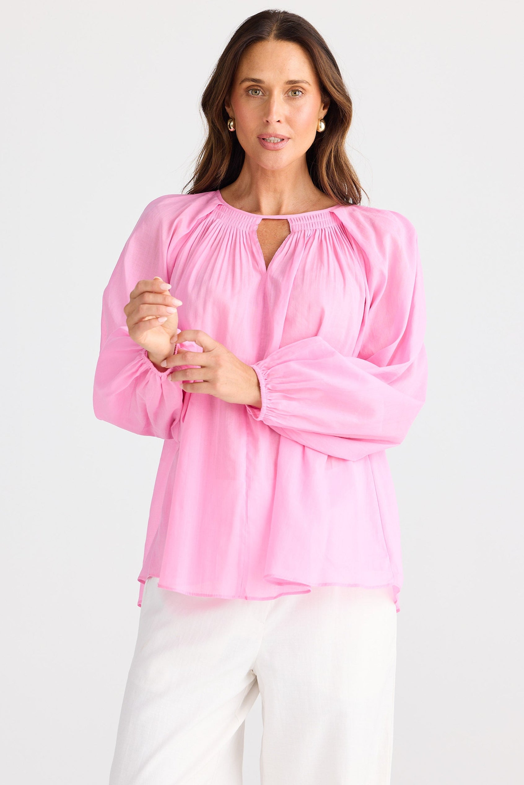 Woman wearing a pink blouse with a plain background