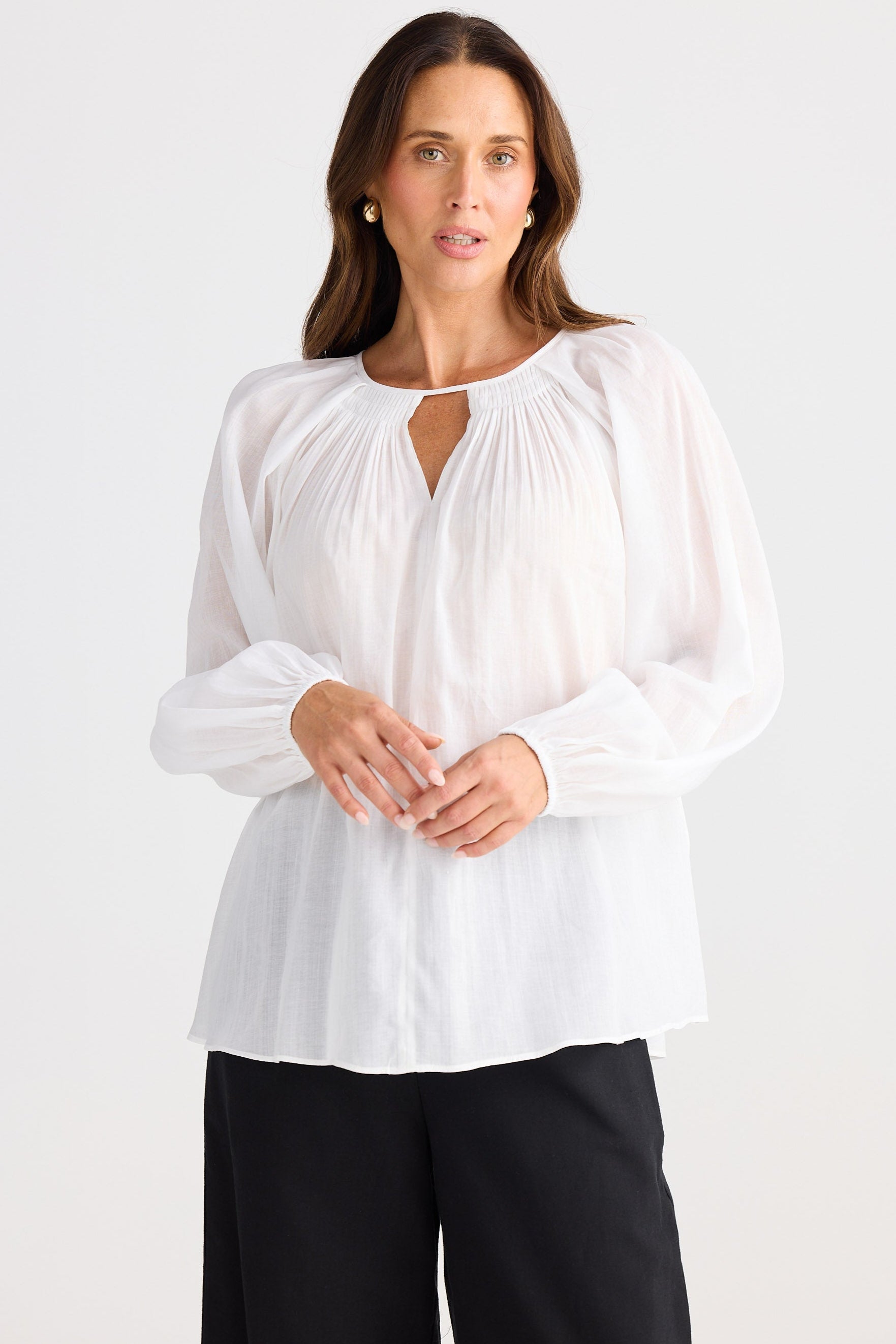 Woman wearing a white blouse with a plain background