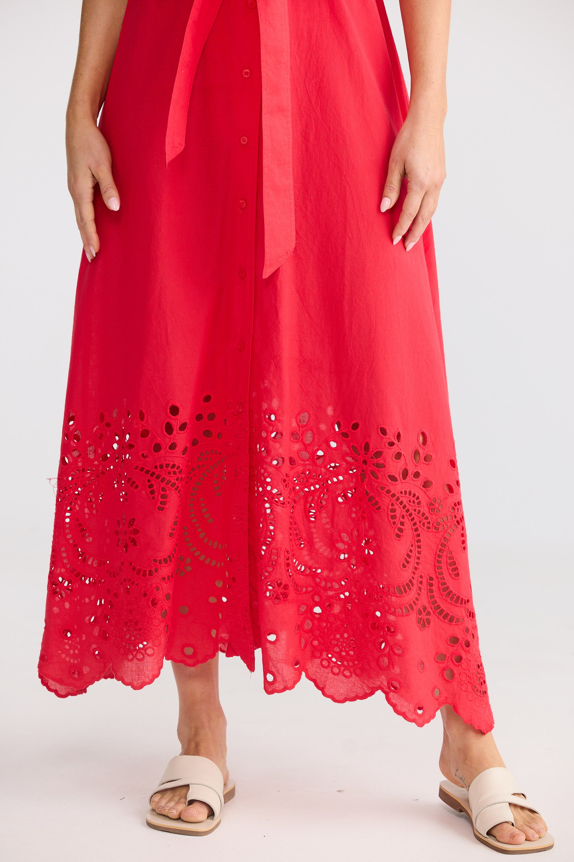Red dress with intricate cut-out pattern on a white background
