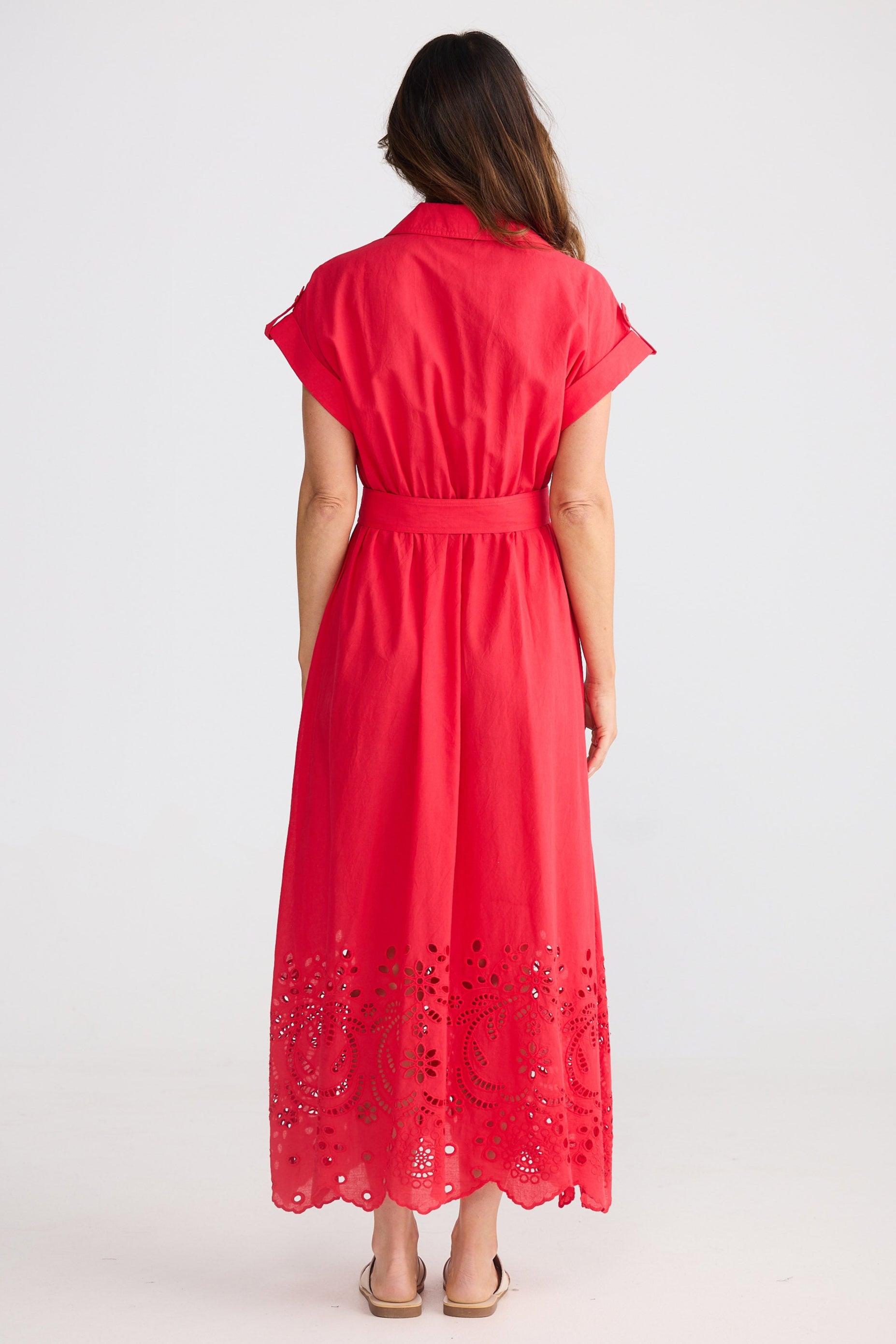 Woman wearing a red dress with lace details on a white background