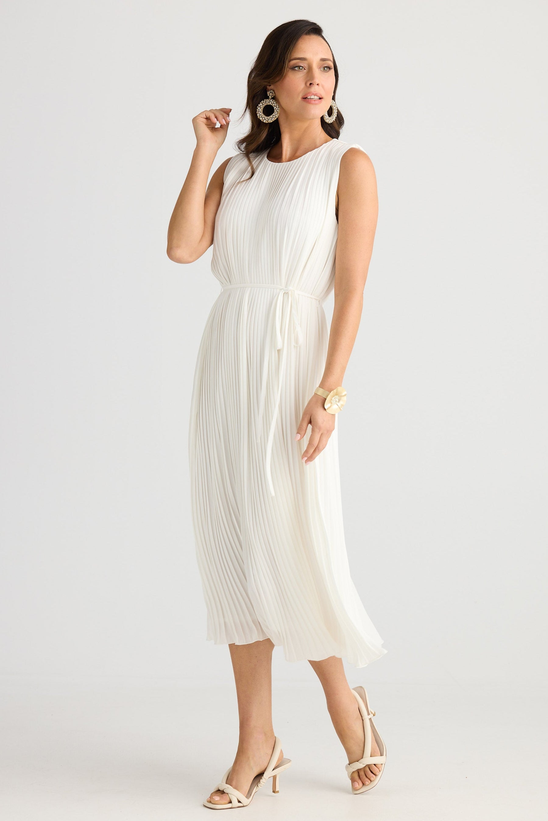 Woman wearing a white dress on a plain background