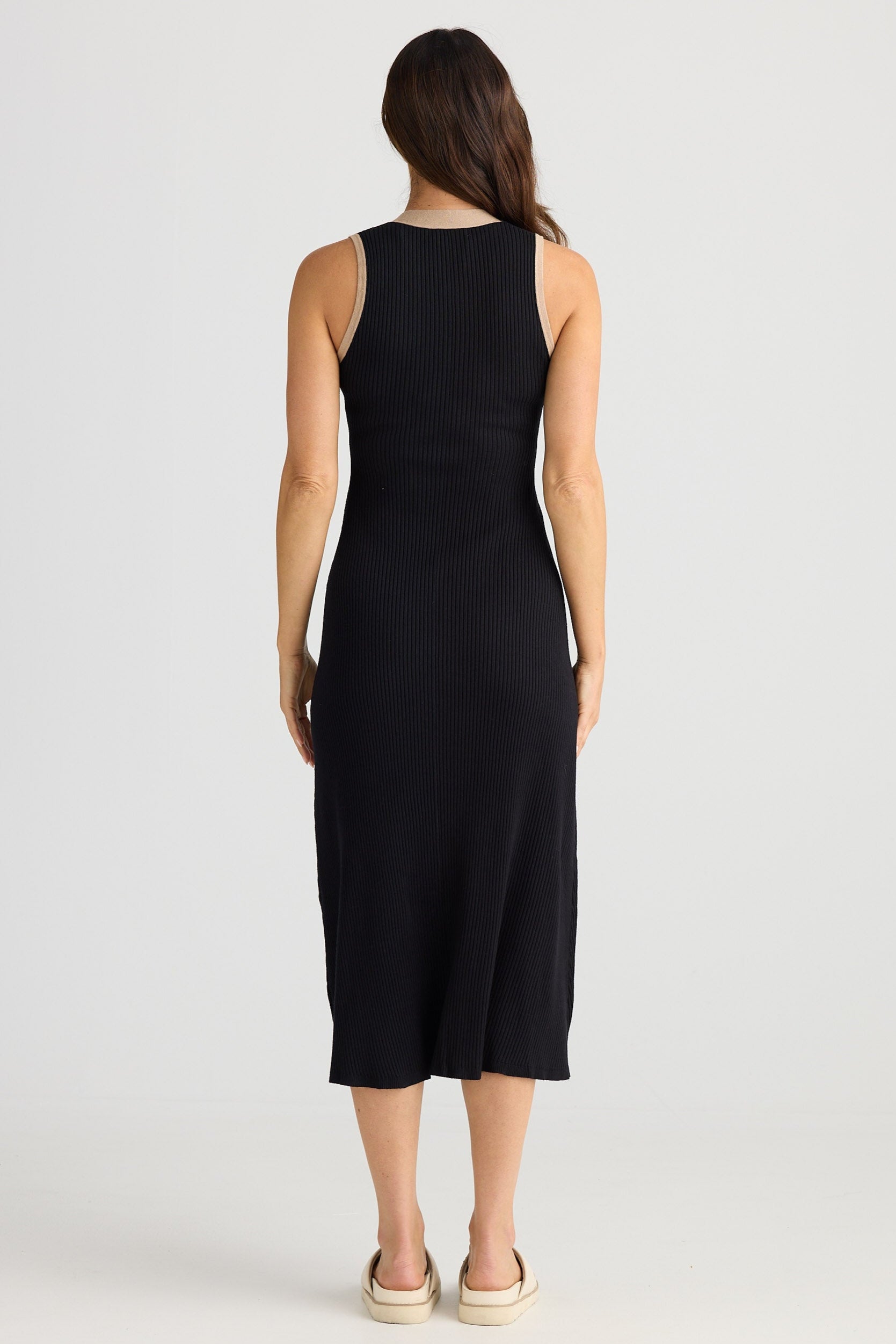 Woman wearing a black sleeveless dress on a white background