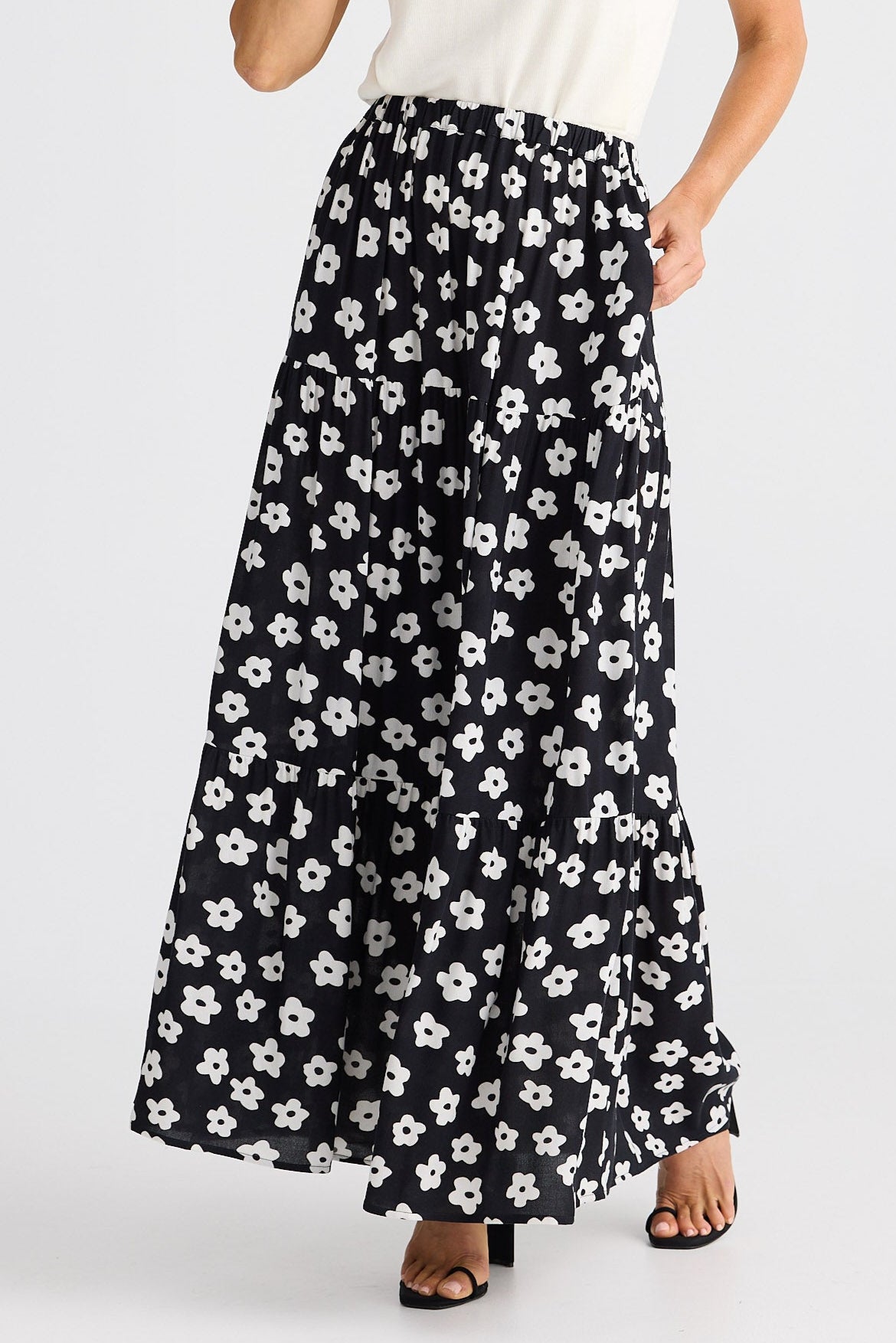 Black floral patterned skirt worn by a person on a white background