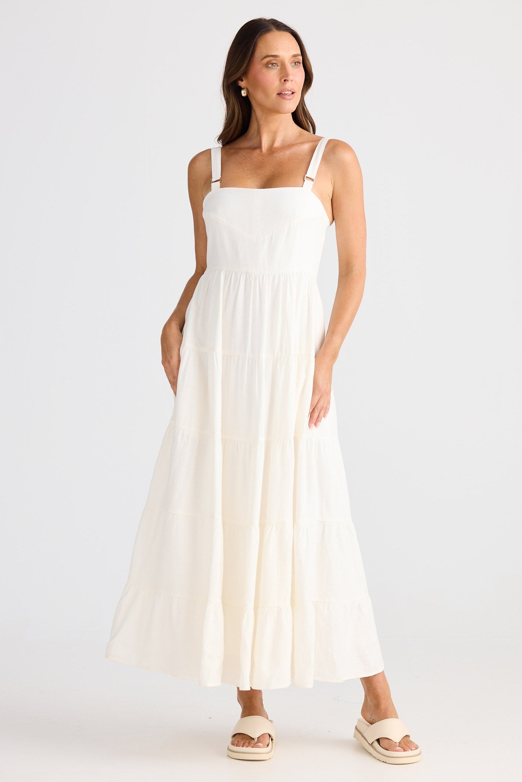 Woman wearing a white dress on a plain background