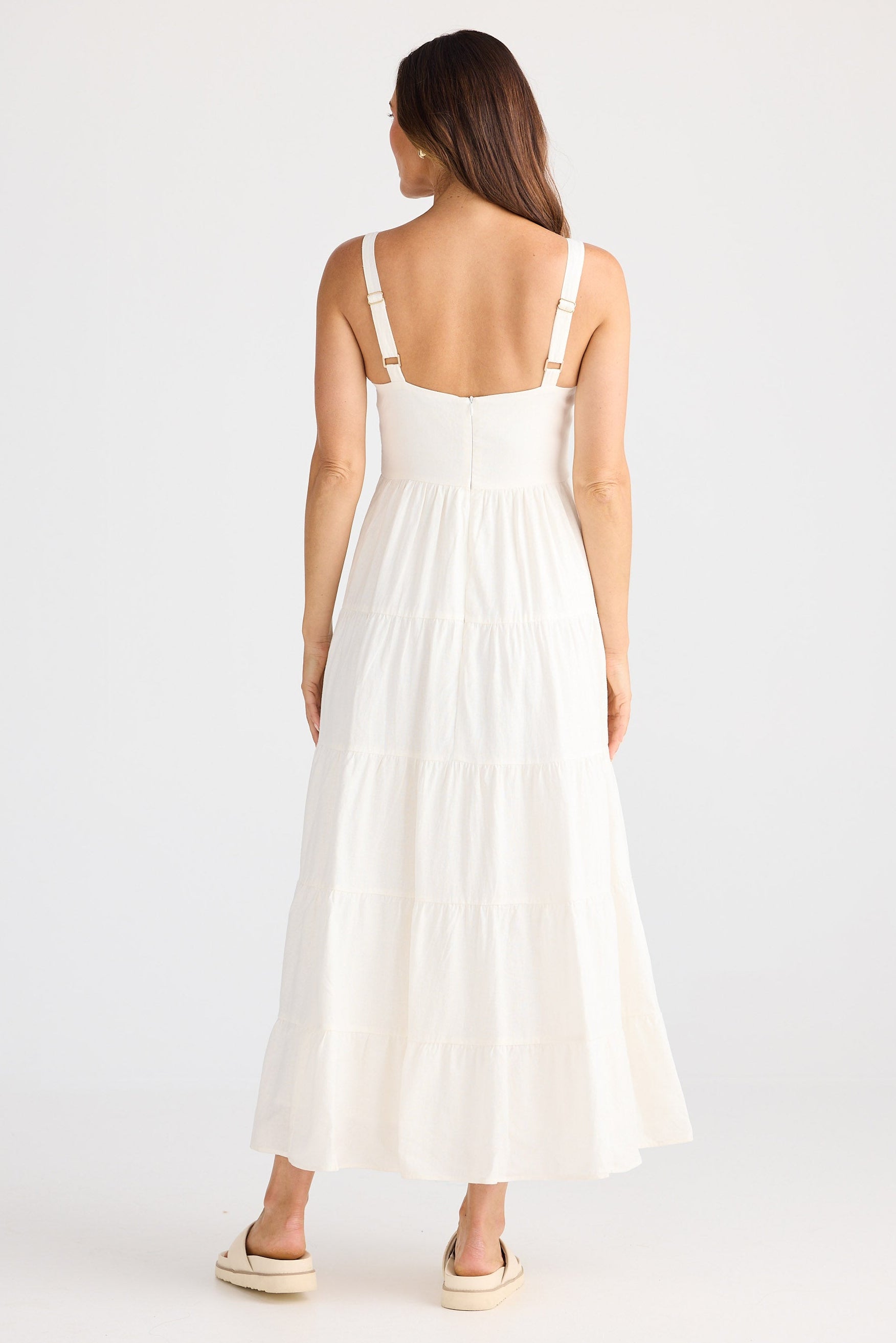 Woman wearing a white dress on a plain background