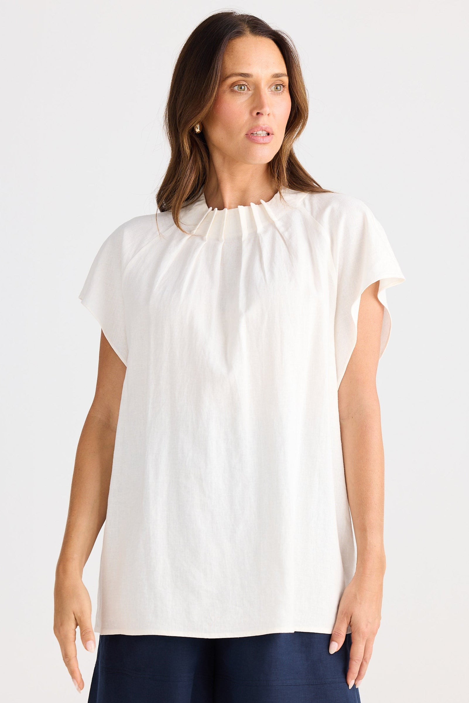 Woman wearing a white blouse with a navy skirt on a white background