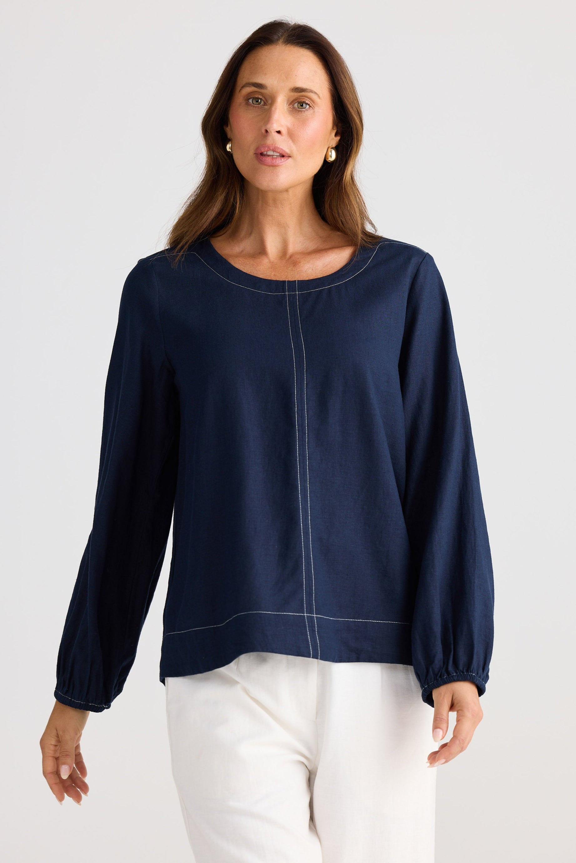 Woman wearing a navy blue top with long sleeves on a white background