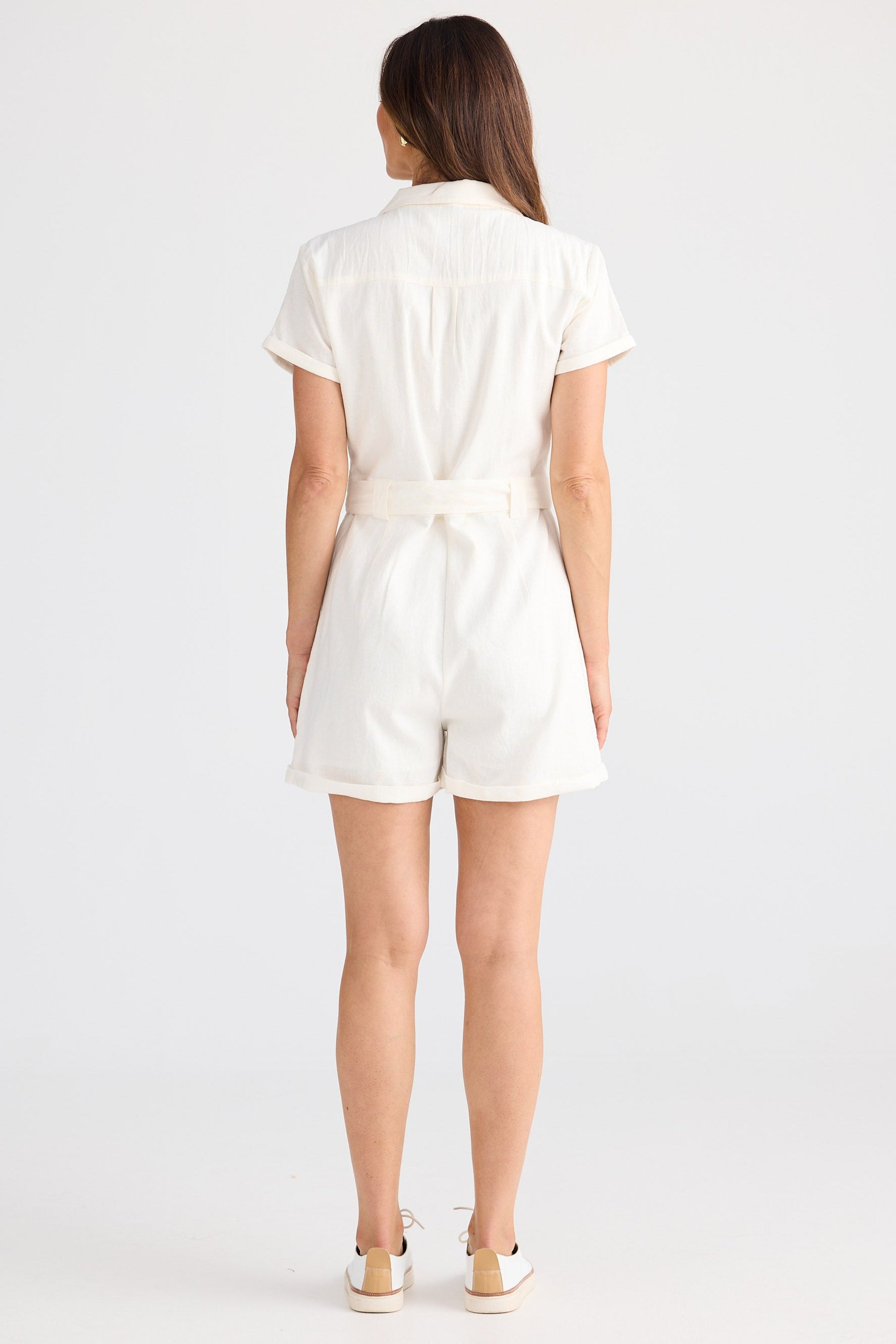 Woman wearing a white romper on a white background
