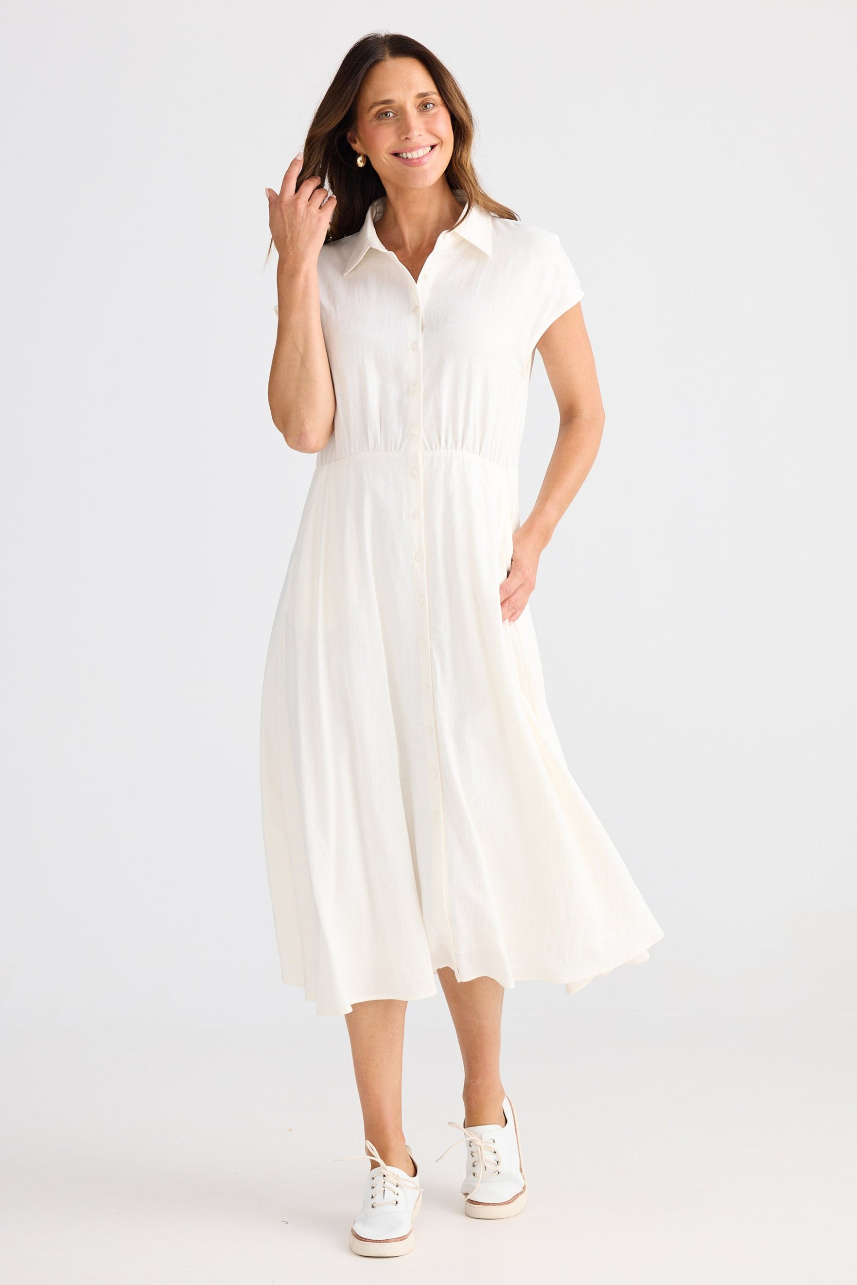 Woman wearing a white dress on a plain background
