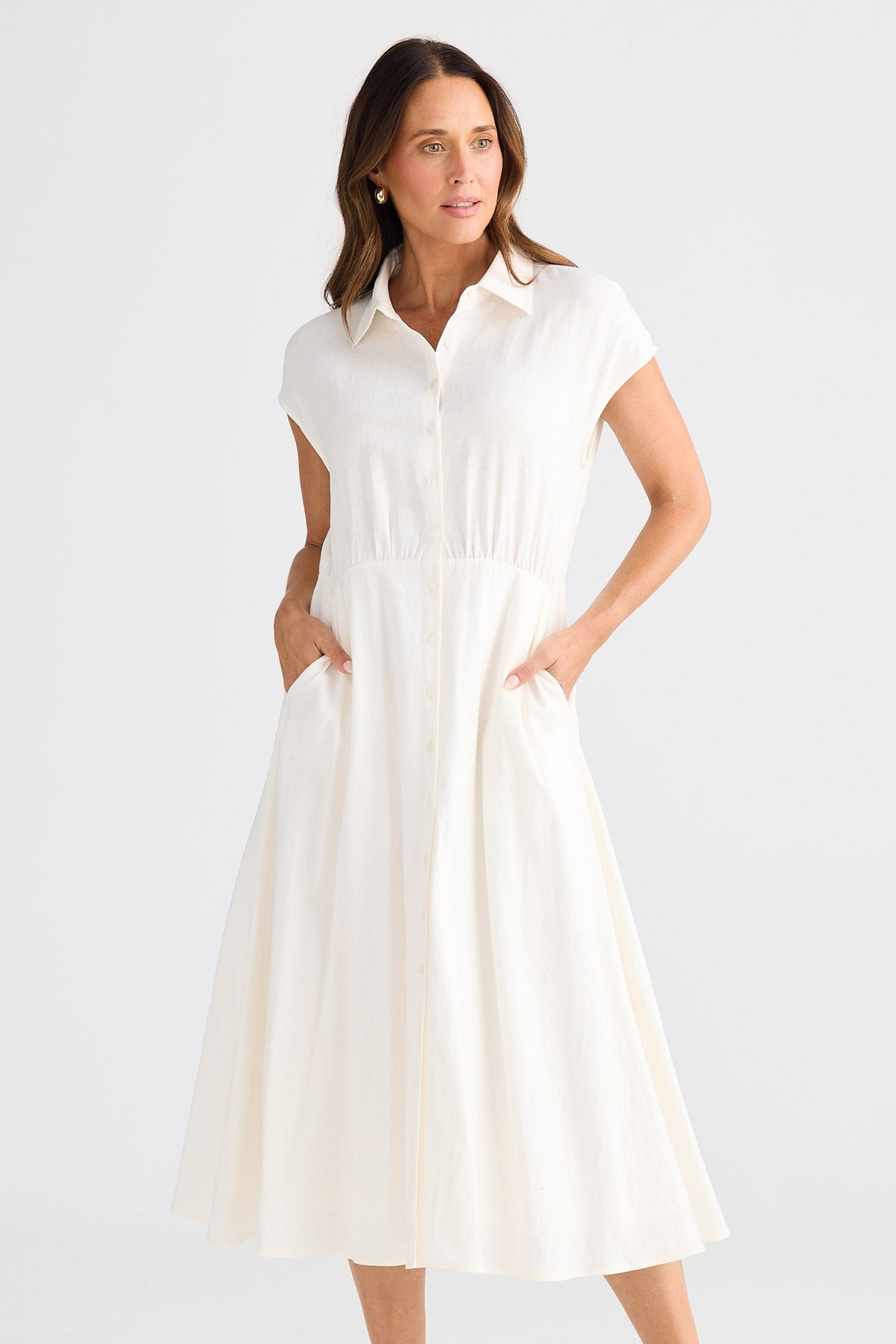 Woman wearing a white dress on a plain background