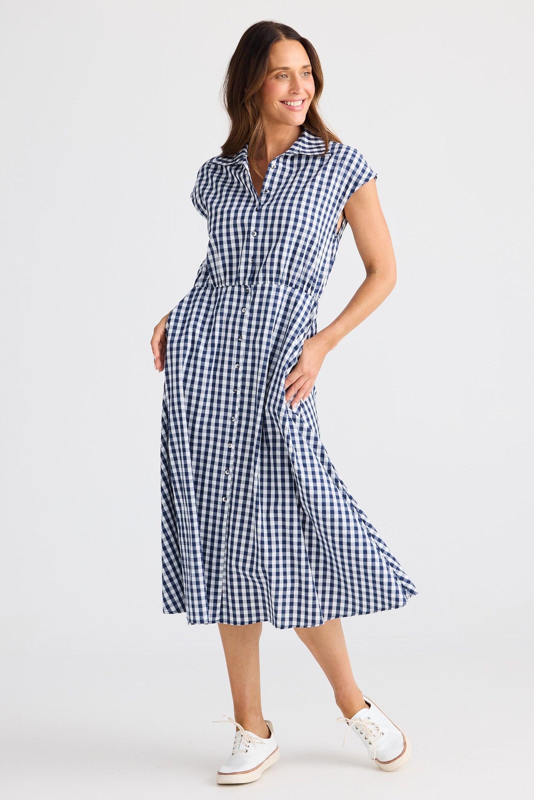 Woman wearing a blue and white checkered dress on a light gray background