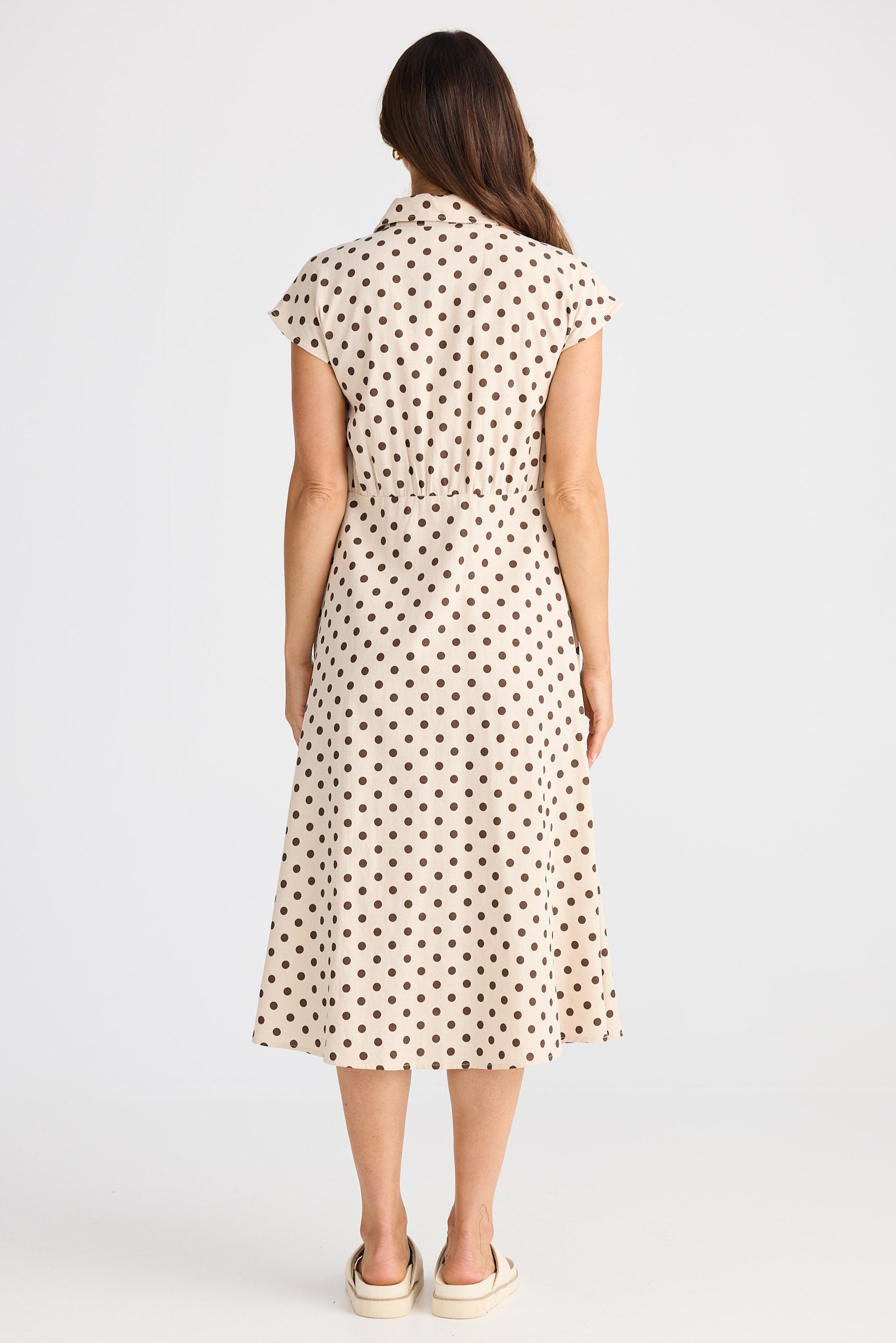 Woman wearing a polka dot dress on a white background