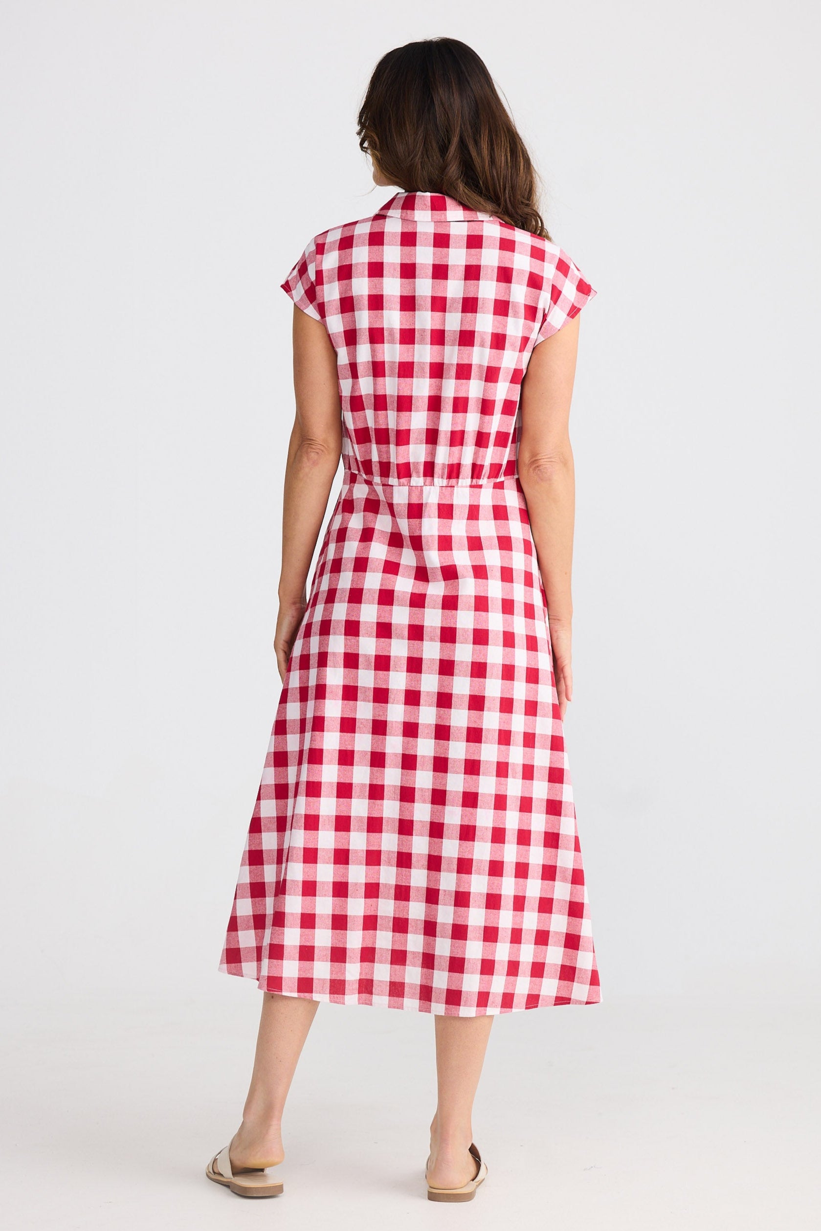 Woman wearing a red and white checkered dress on a white background