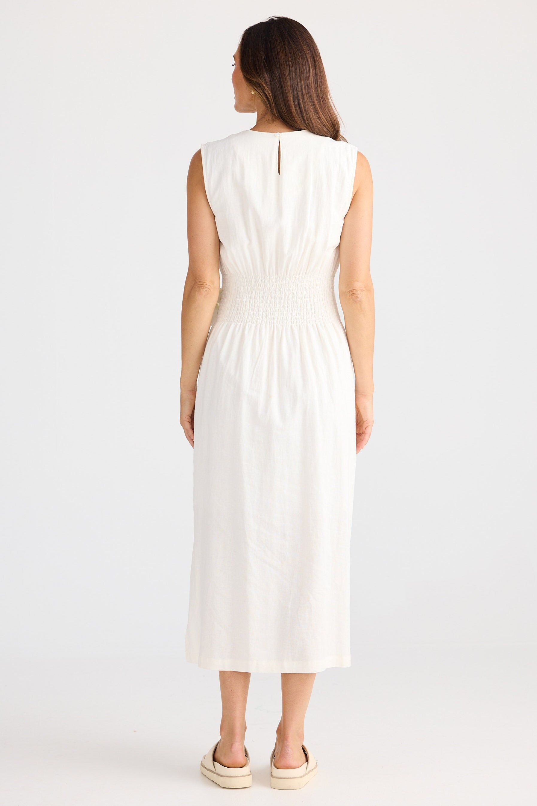 Woman wearing a white sleeveless dress on a white background