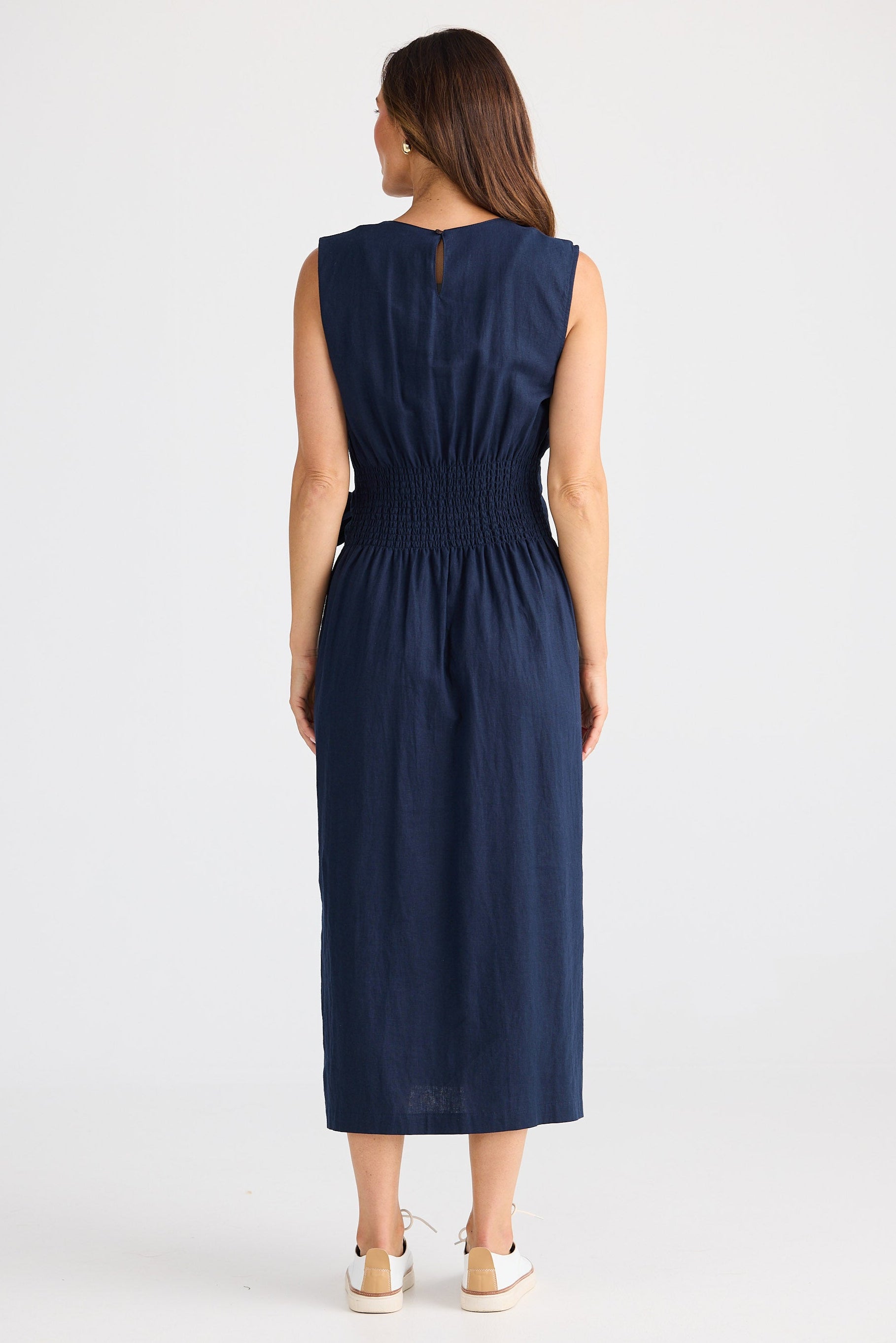 Woman wearing a navy dress on a white background