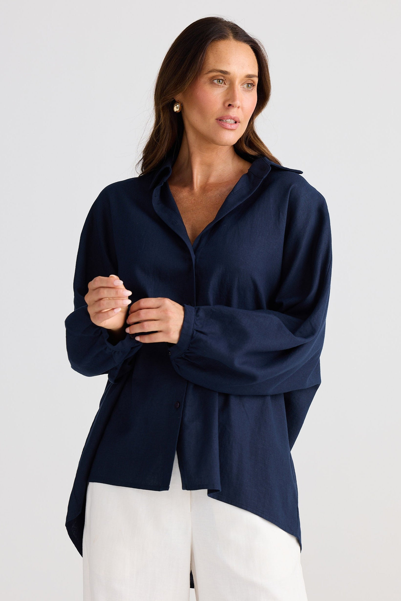 Woman wearing a navy blue top with a plain background
