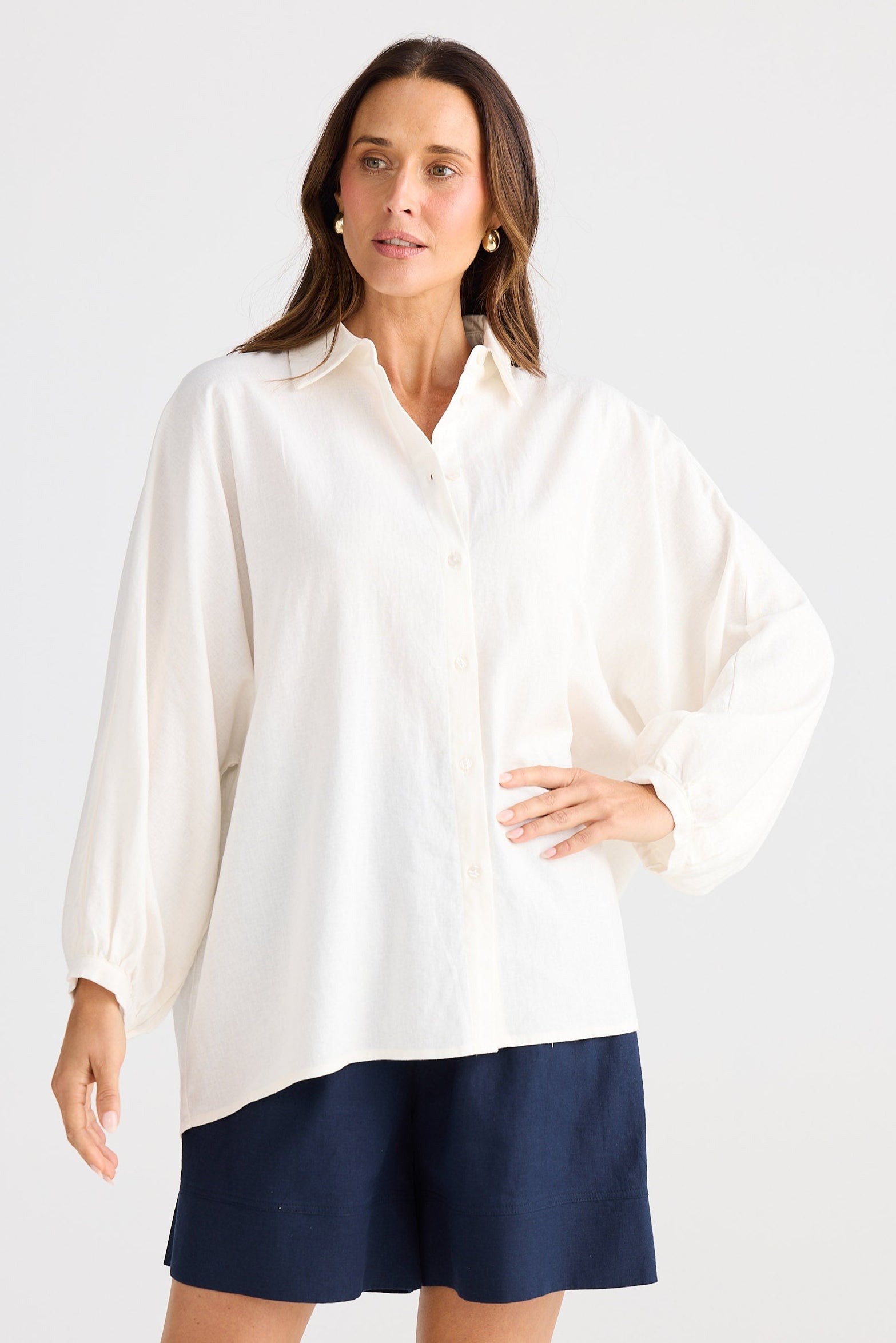 Woman wearing a white shirt with a navy blue skirt on a white background