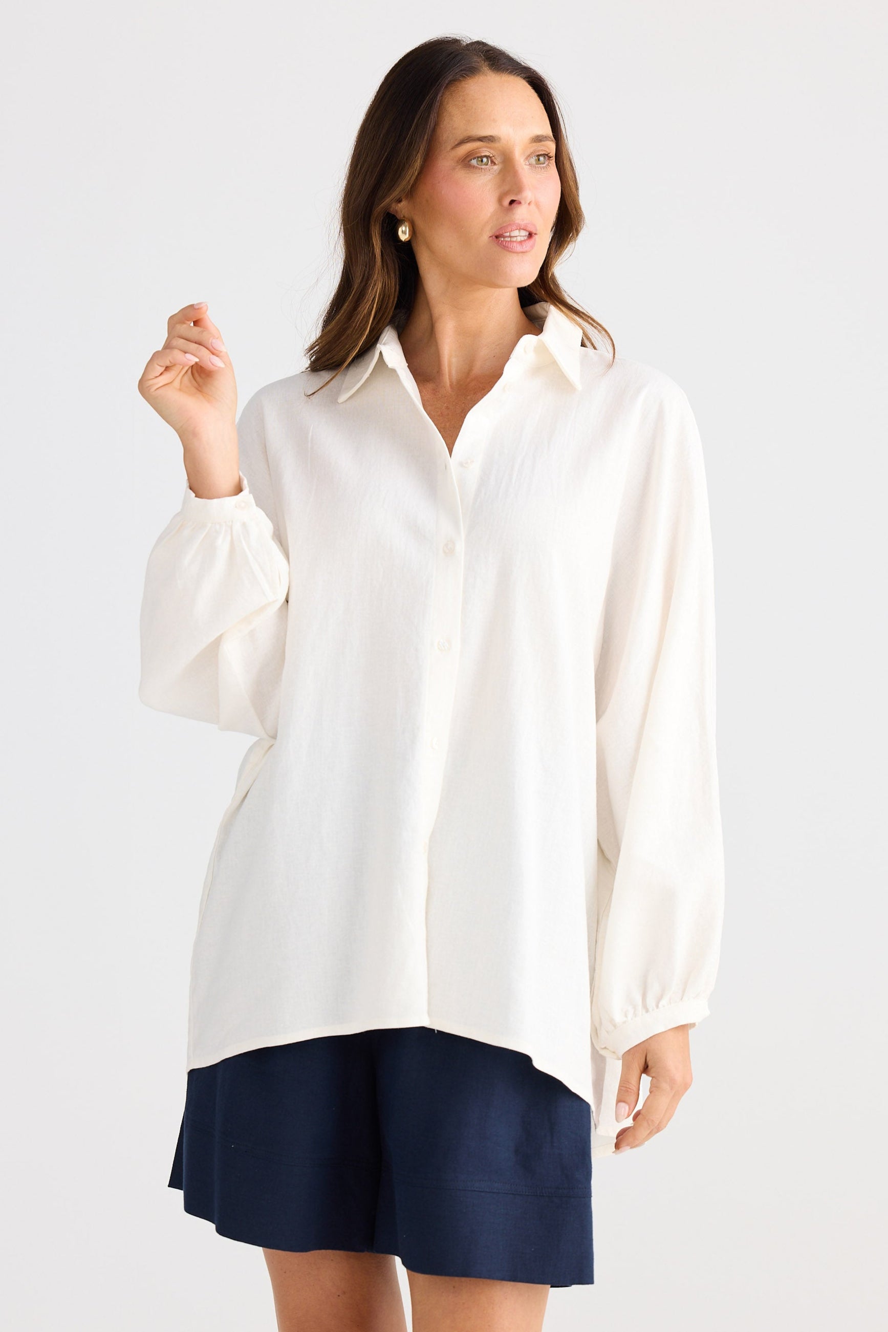 Woman wearing a white shirt with a navy skirt on a white background