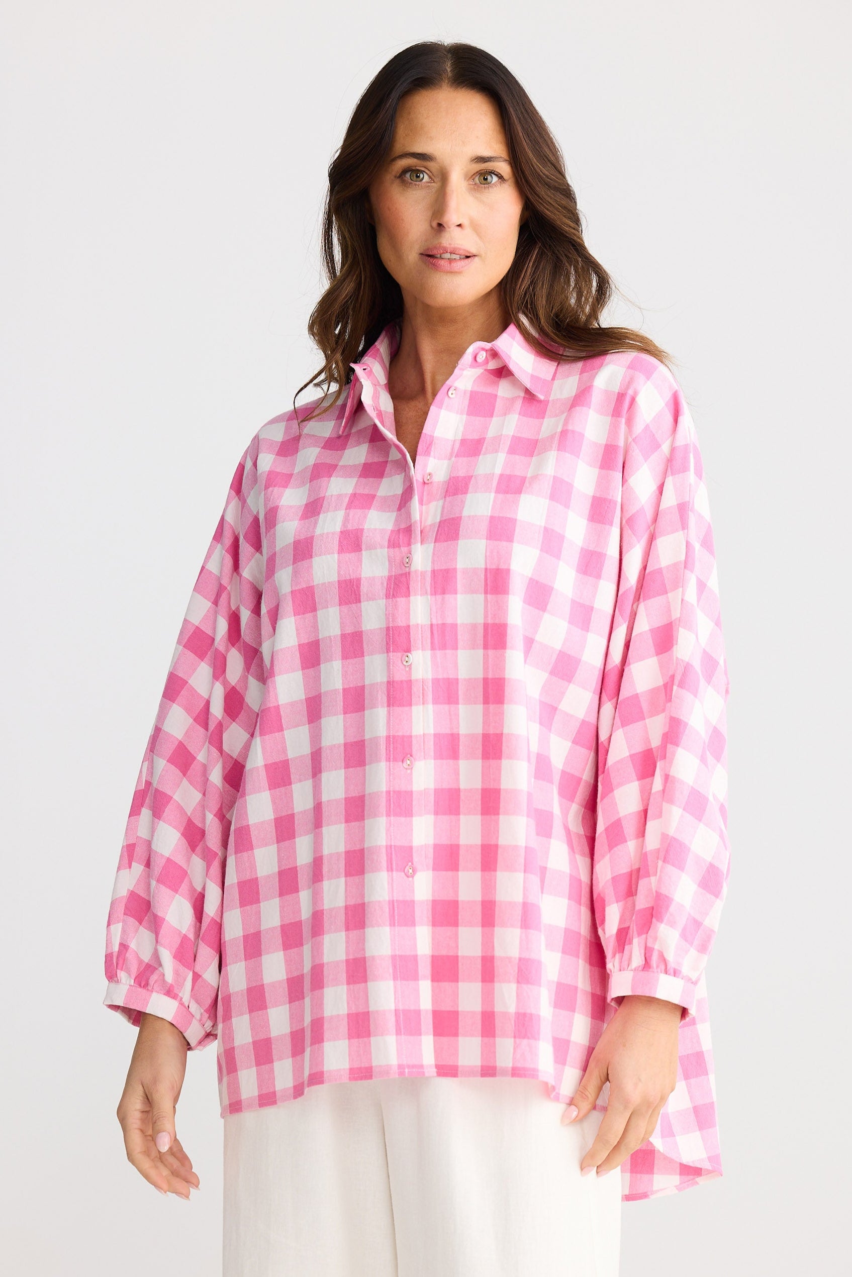 Woman wearing a pink and white checkered shirt on a white background