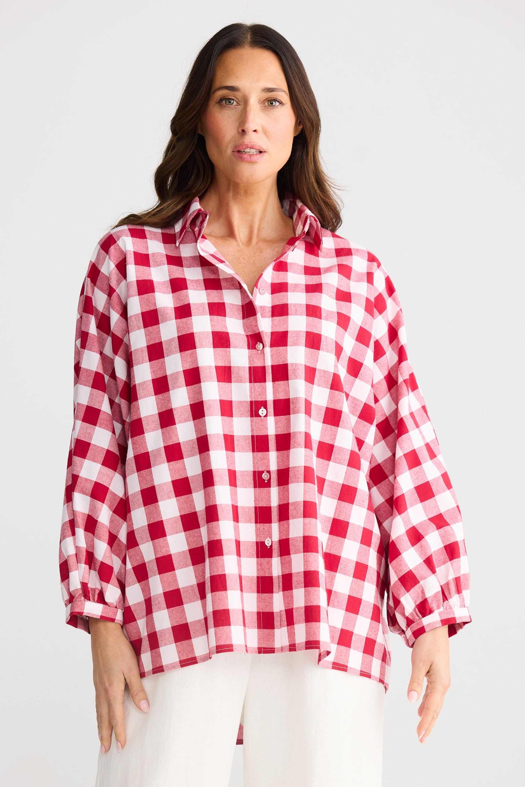 Woman wearing a red and white checkered shirt against a white background