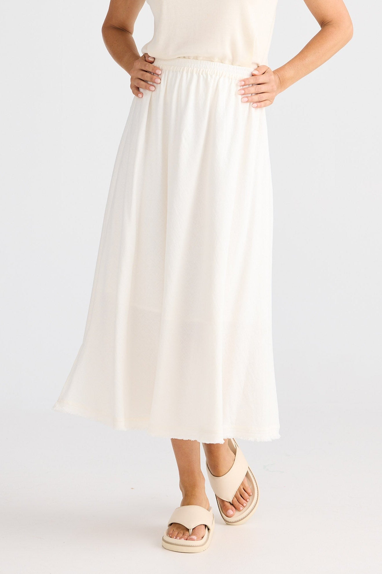 Woman wearing a white skirt on a plain background