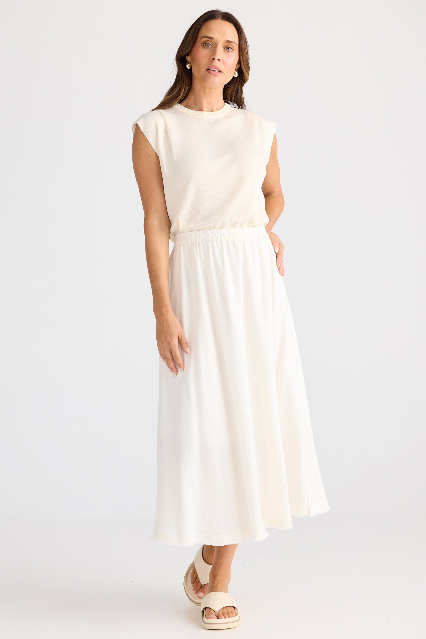 Woman wearing a white dress against a plain background