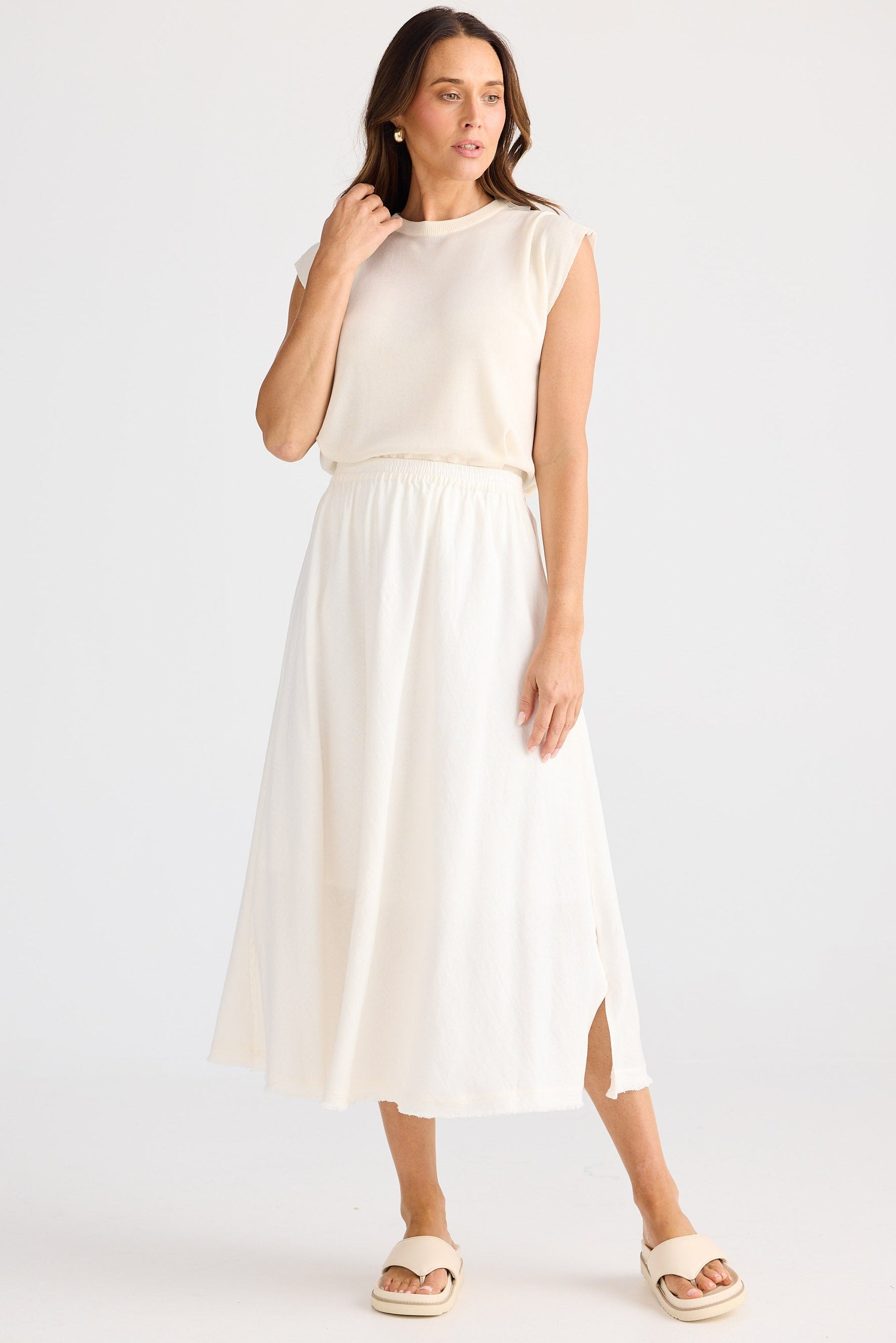 Woman wearing a white sleeveless top and skirt set on a white background