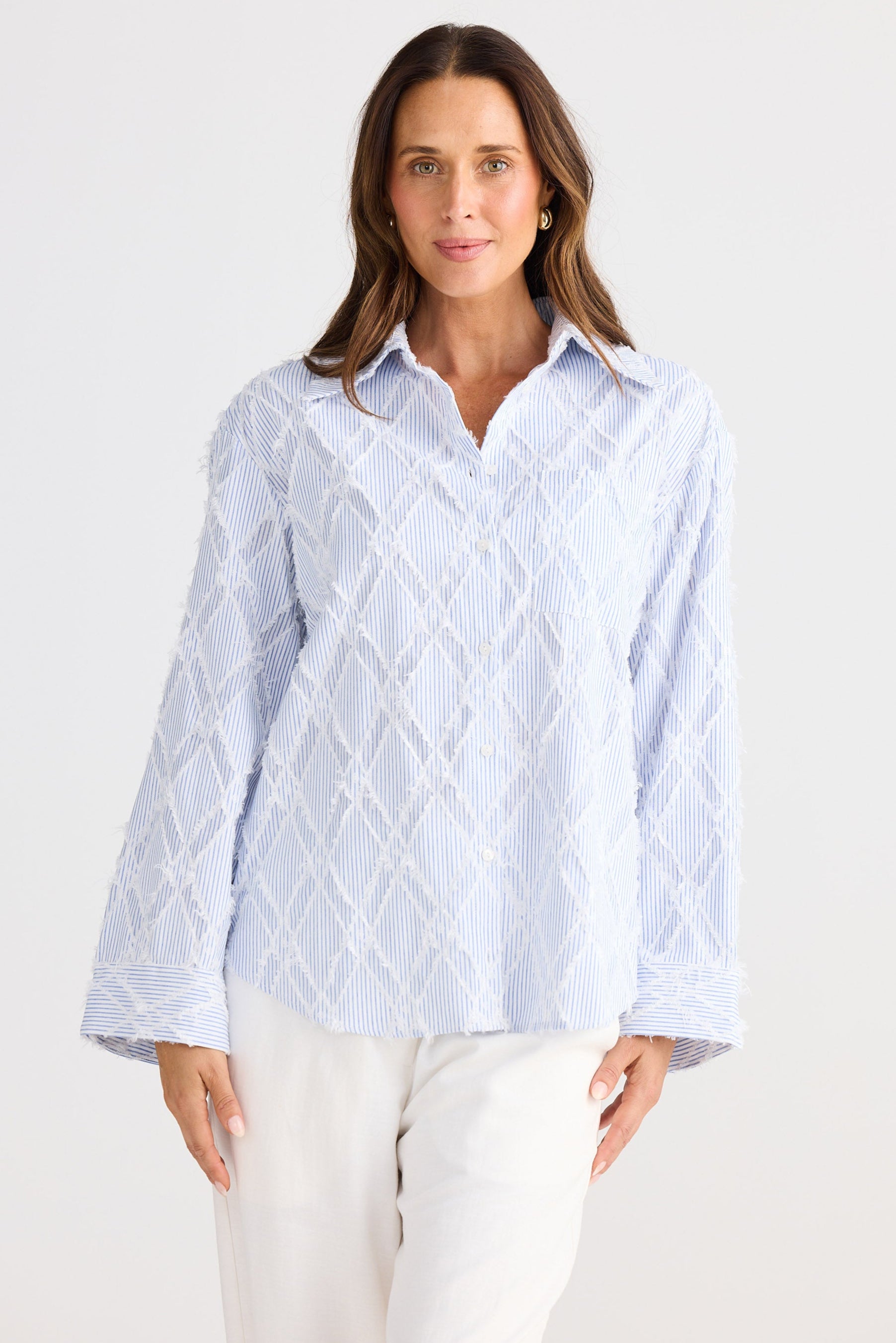 Woman wearing a light blue patterned shirt on a white background