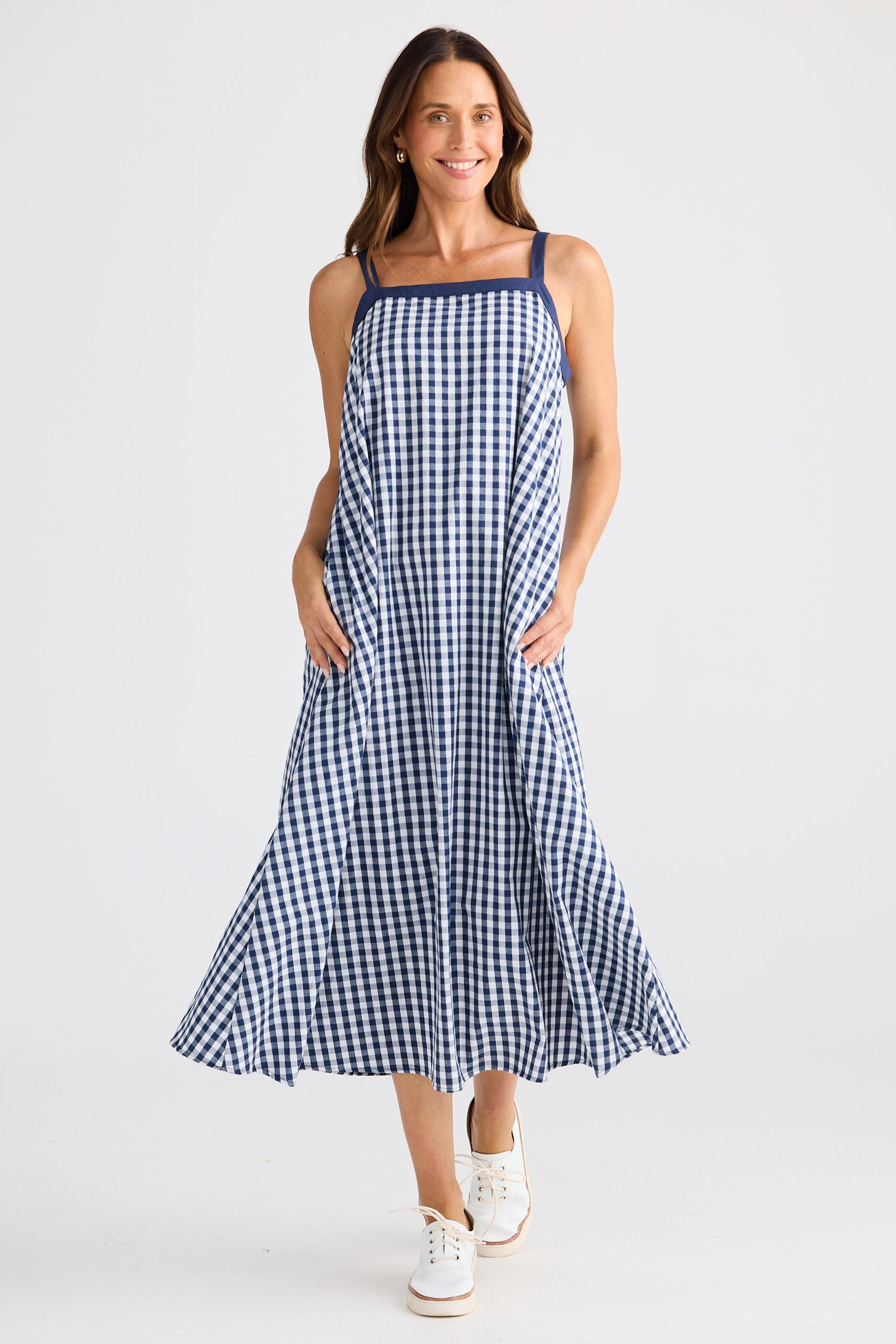 Woman wearing a blue and white checkered dress on a white background