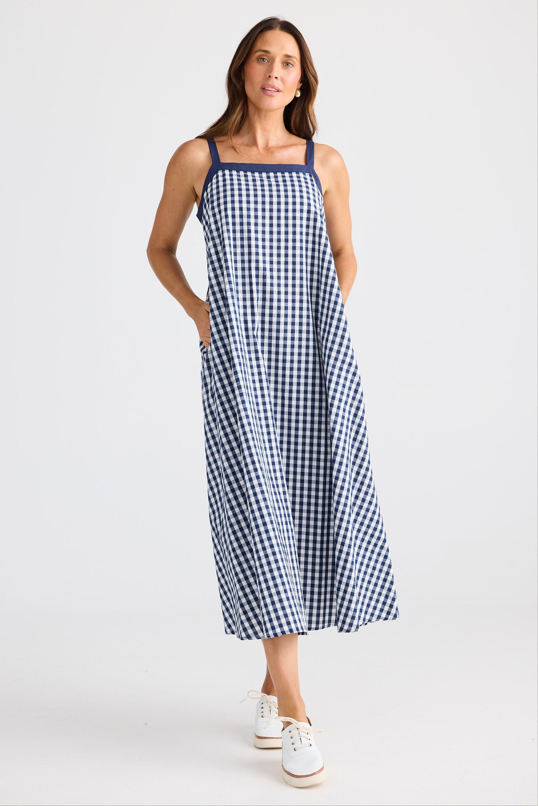 Woman wearing a blue and white checkered dress on a white background