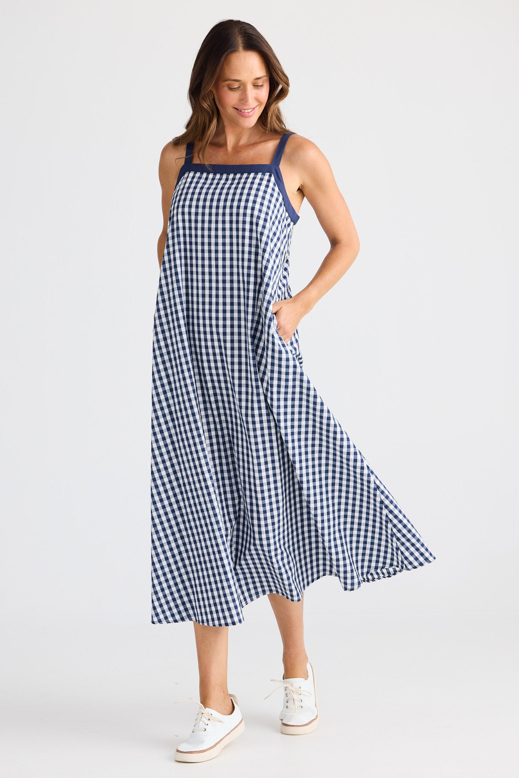 Woman wearing a blue and white checkered dress on a white background