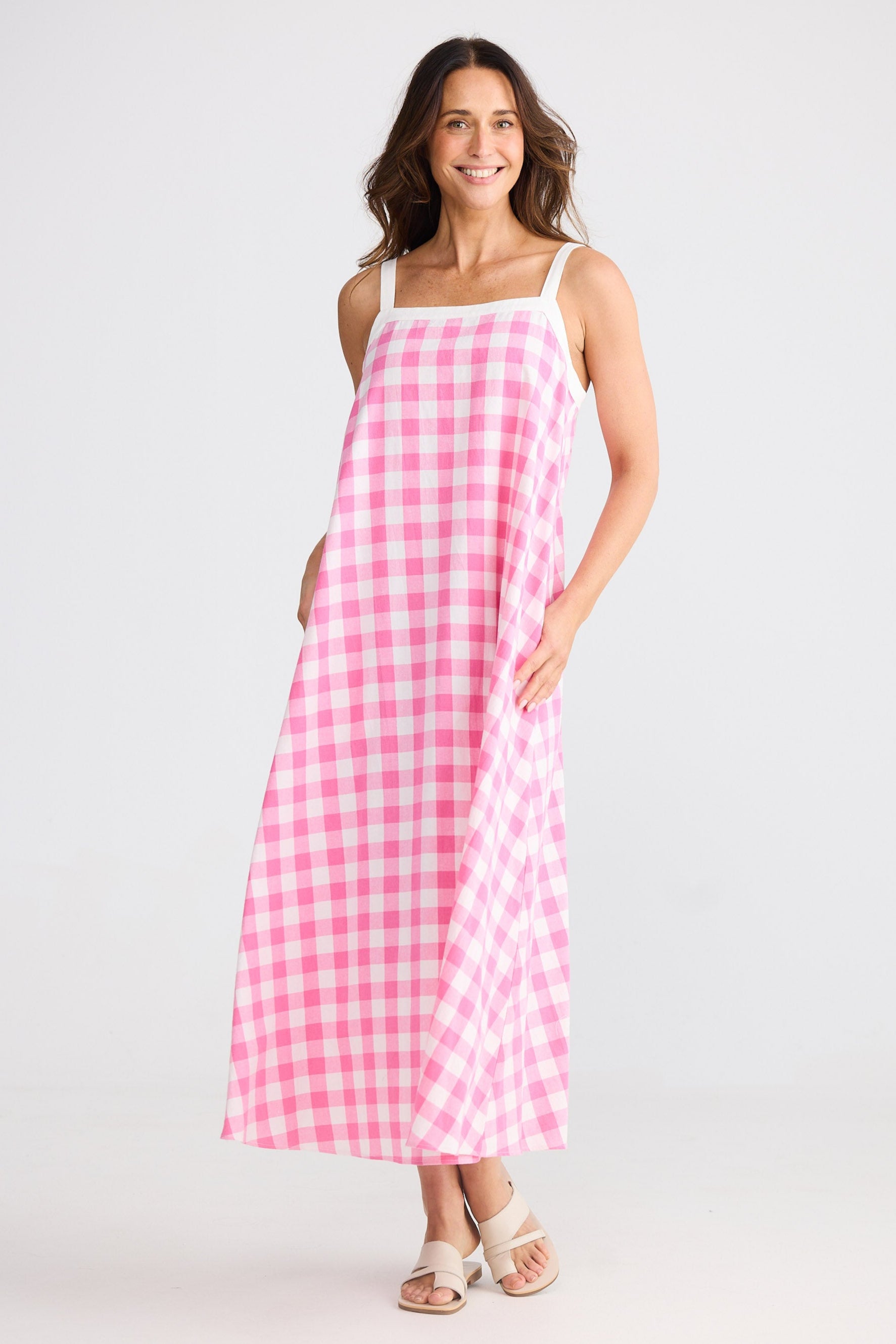 Woman wearing a pink gingham dress against a white background