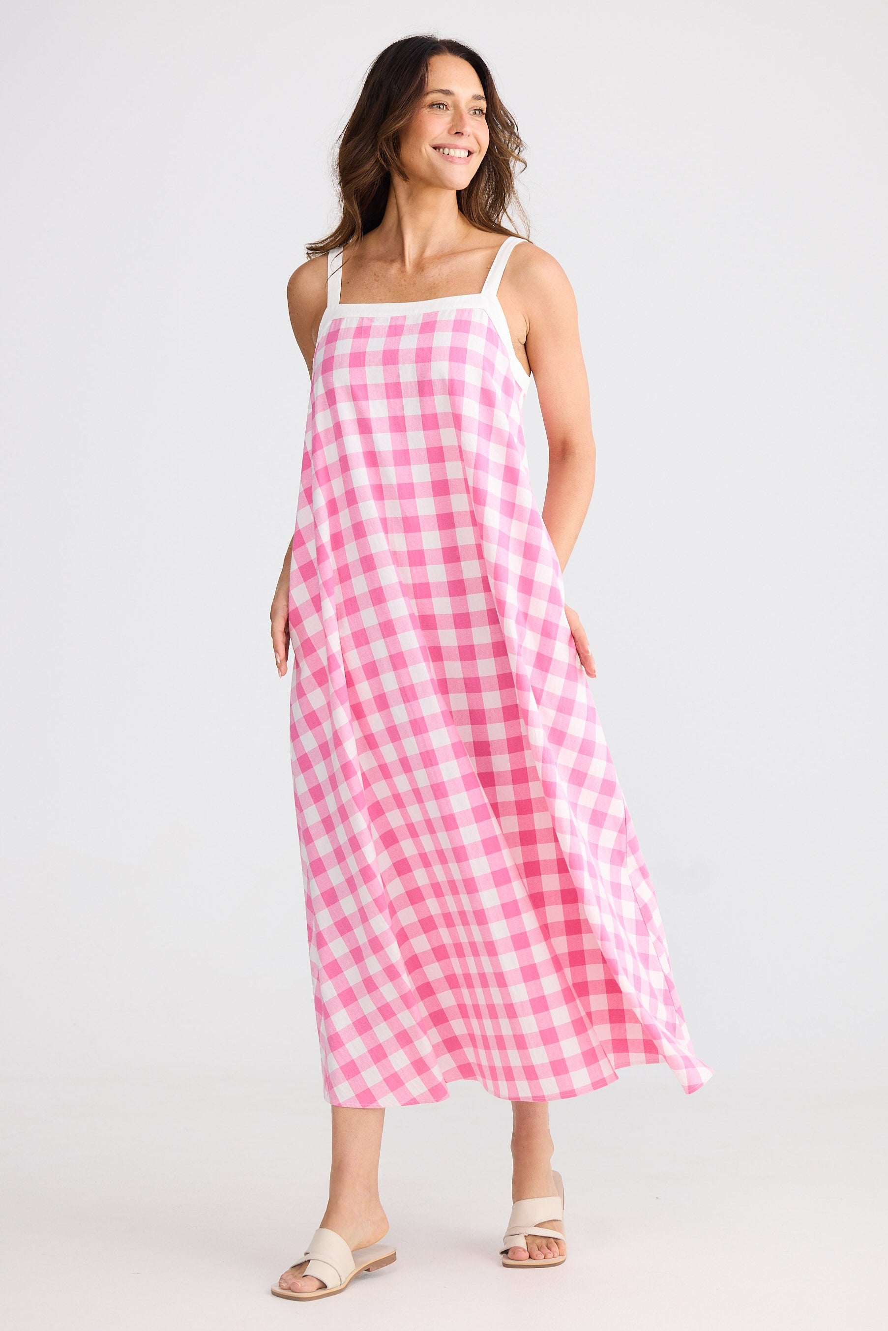Woman wearing a pink and white checkered dress on a white background