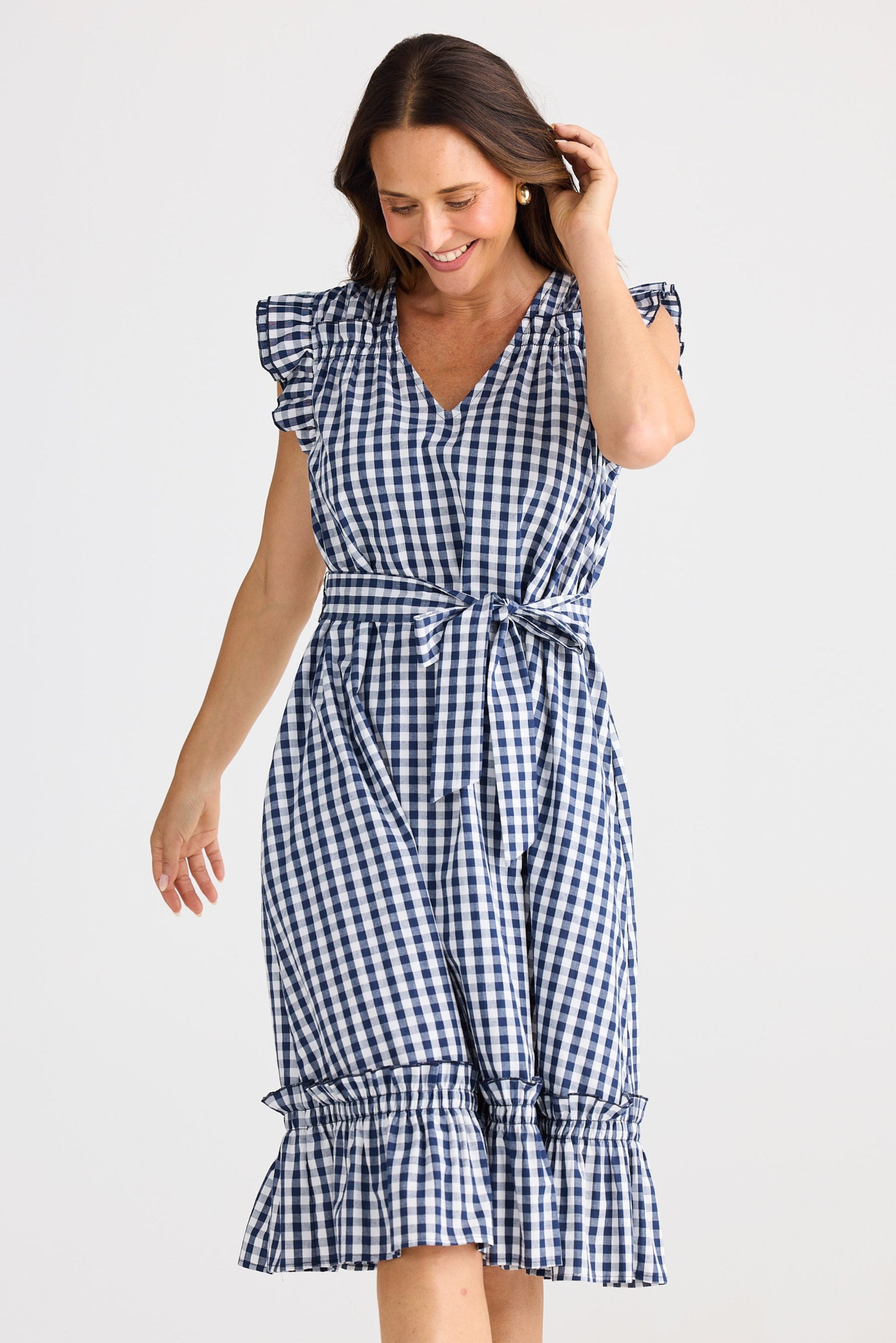 Woman wearing a blue and white checkered dress on a light background