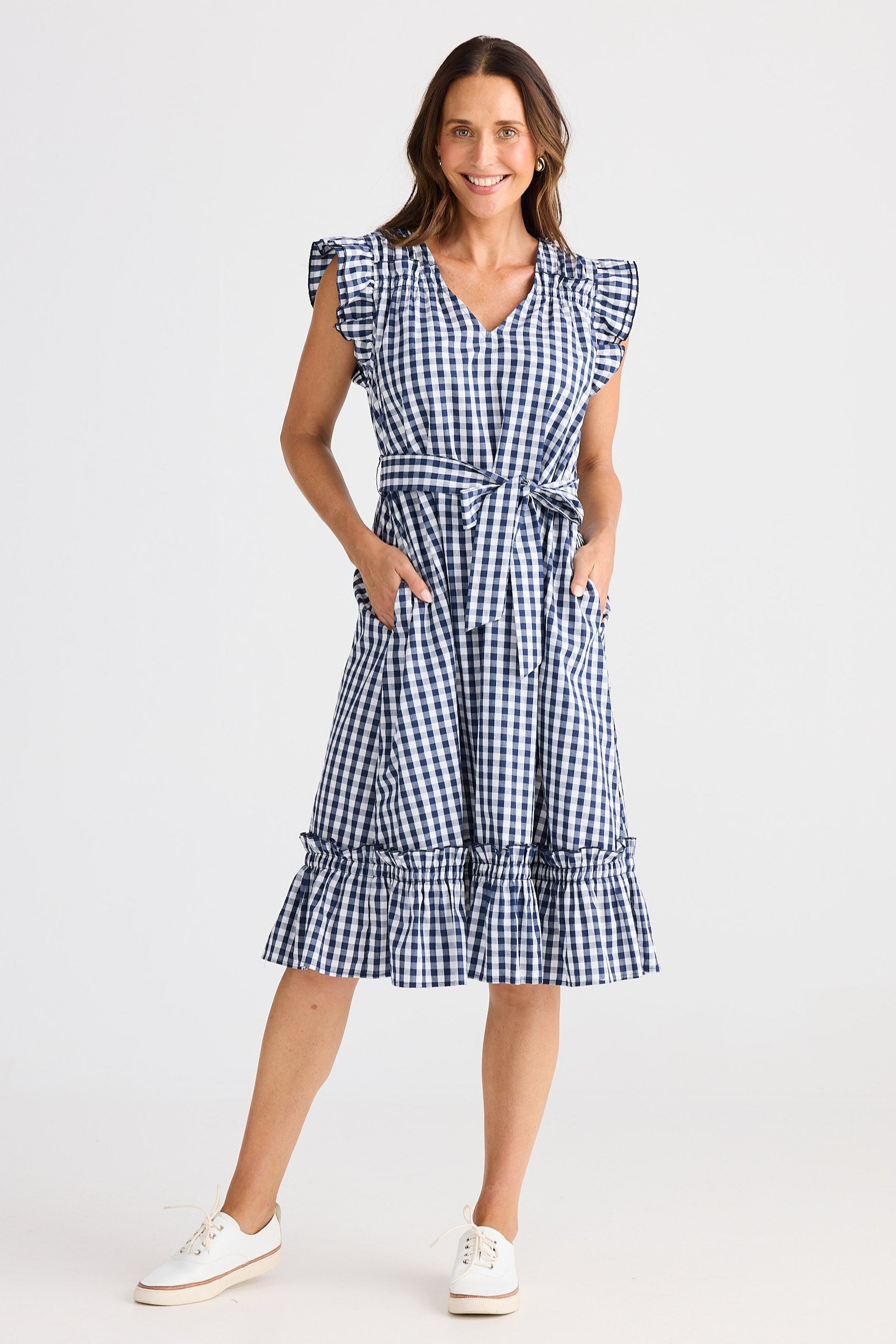Woman wearing a blue and white checkered dress on a white background