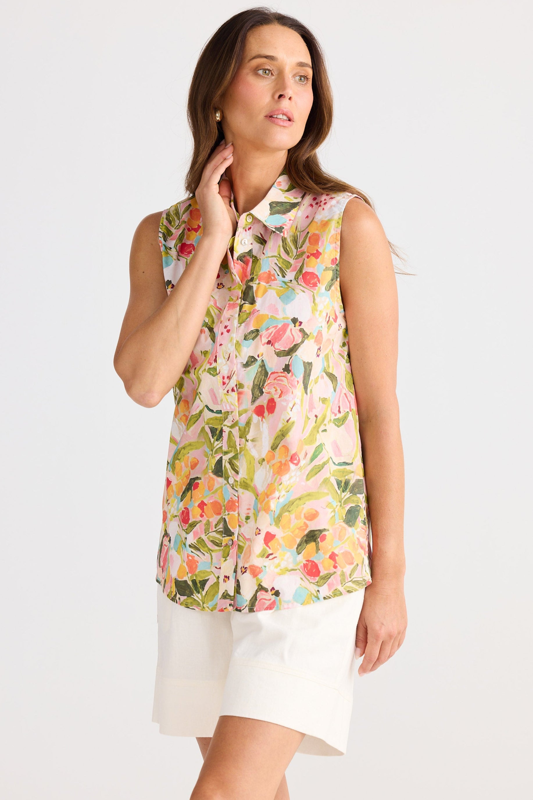 Woman wearing a sleeveless floral blouse on a white background